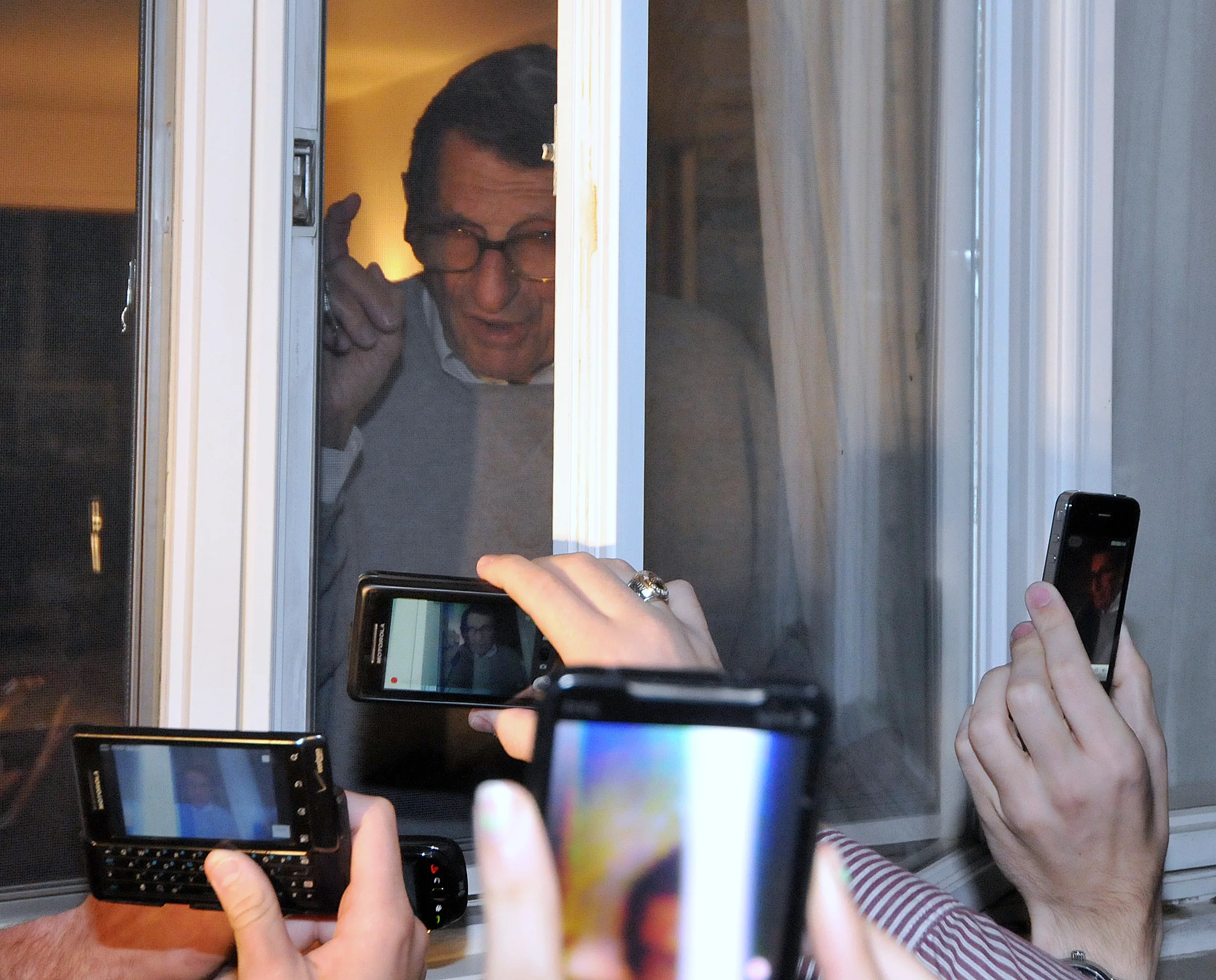 Head coach Joe Paterno speaks to fans and media from inside his window on Tuesday night. A group of about 300 people gathered in support of Paterno.