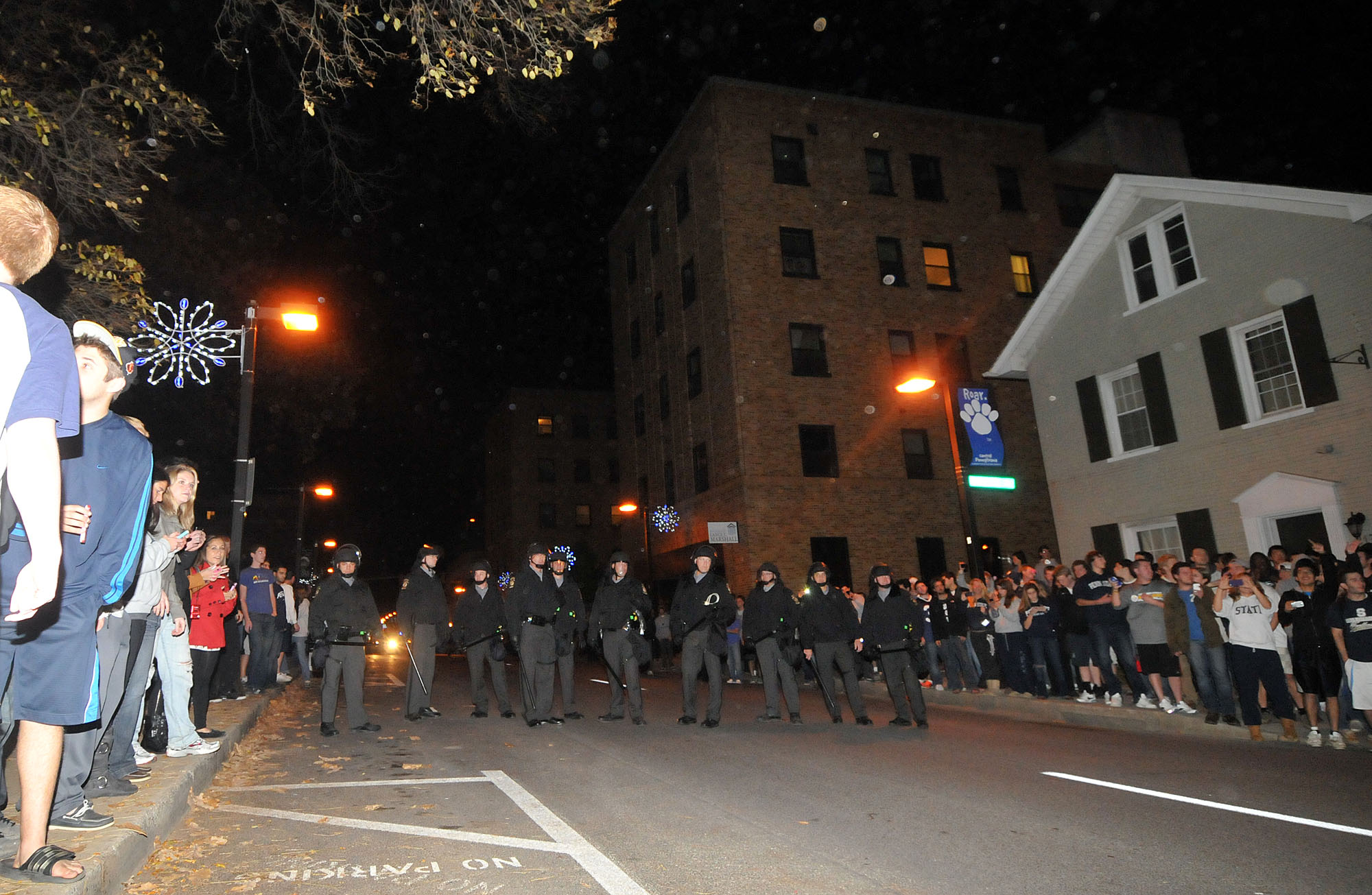  Policemen line the street of Beaver Avenue on Tuesday night to keep back protesters. They asked for students to clear the street, though many remained on the sidewalk chanting "USA," "Joe-pa-terno," and "We Are." 