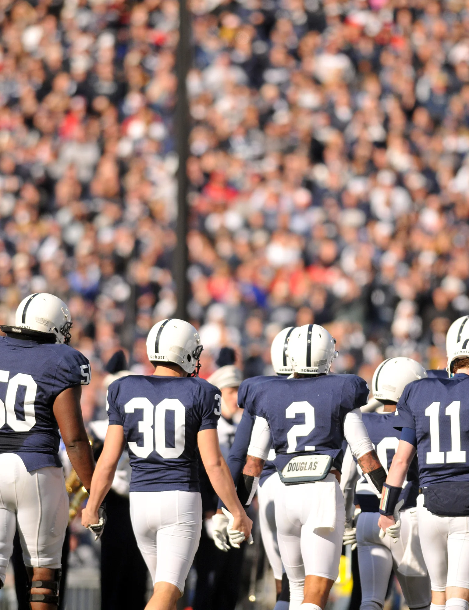Players walk onto the field holding hands instead of running out before Saturday's game against Nebraska.