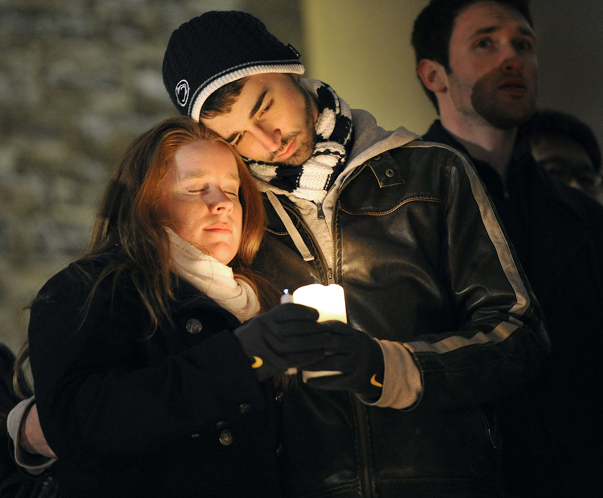  Andrew Adamietz (sophomore-secondary english education) and Katie Knobloch (senior-elementary education), both members of Blue in the Face, embrace on the stairs of Old Main on Sunday night during the candlelit vigil in memorium of Joe Paterno. 