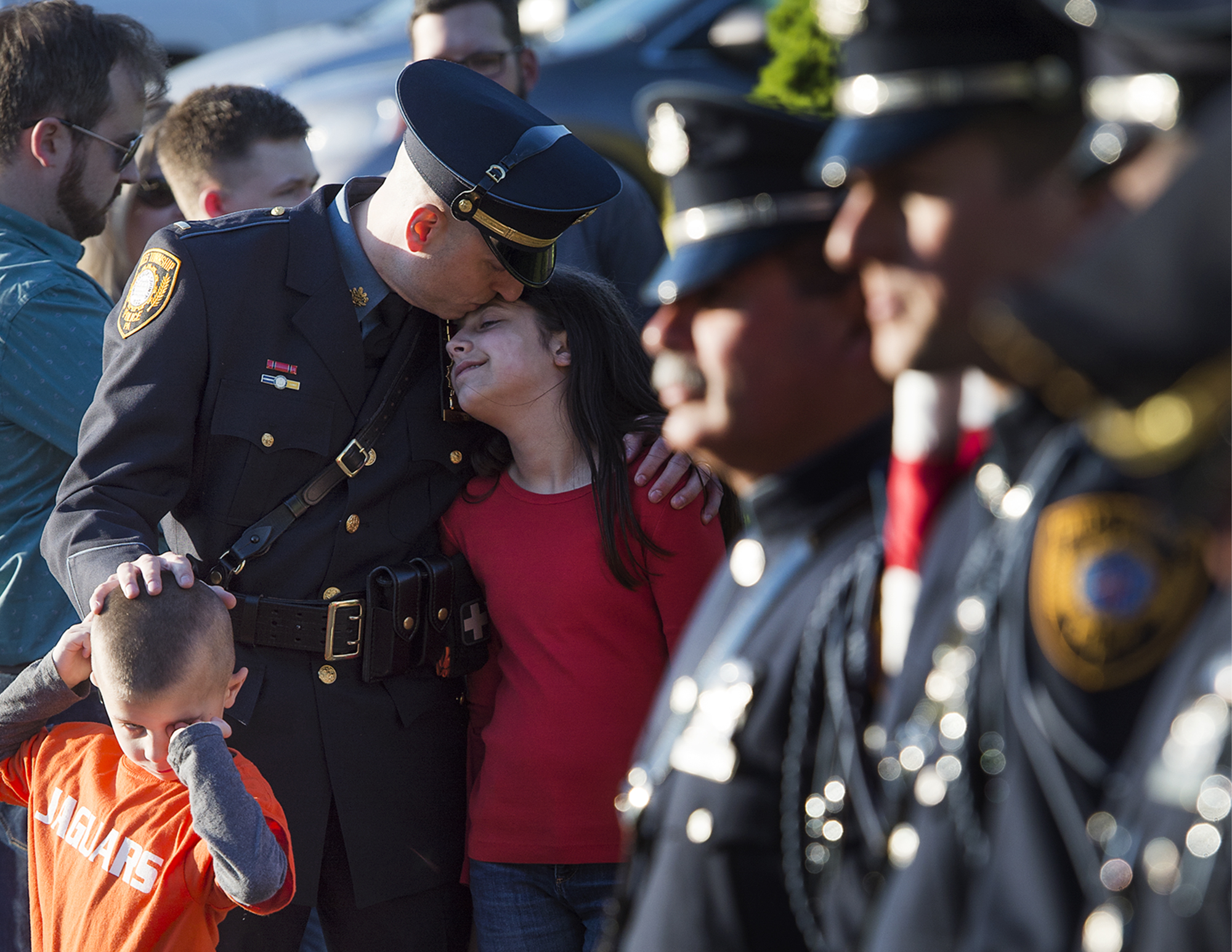  Falls Township Police Lieutenant Nelson Whitney kisses daughter Abigail, 12, with a gentle hand on son Ethan, 6, just two of his five children, before a county-wide blue mass at St. Andrew Catholic Church in Newtown Township. 