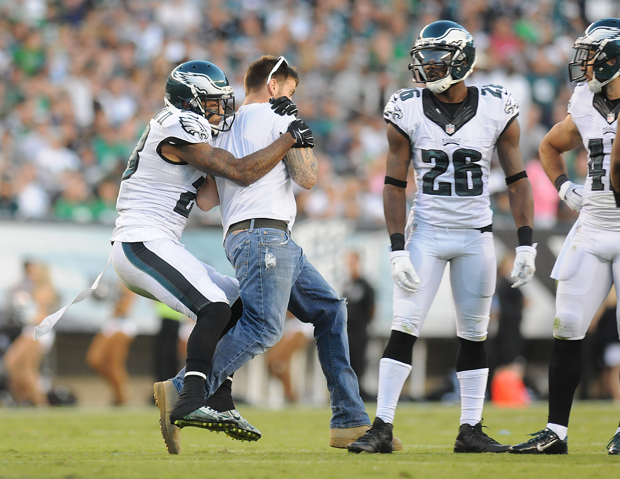  Eagles cornback Nolan Carroll (23) tackles a fan who rushed the field during their game against the Cowboys at Lincoln Financial Field. 