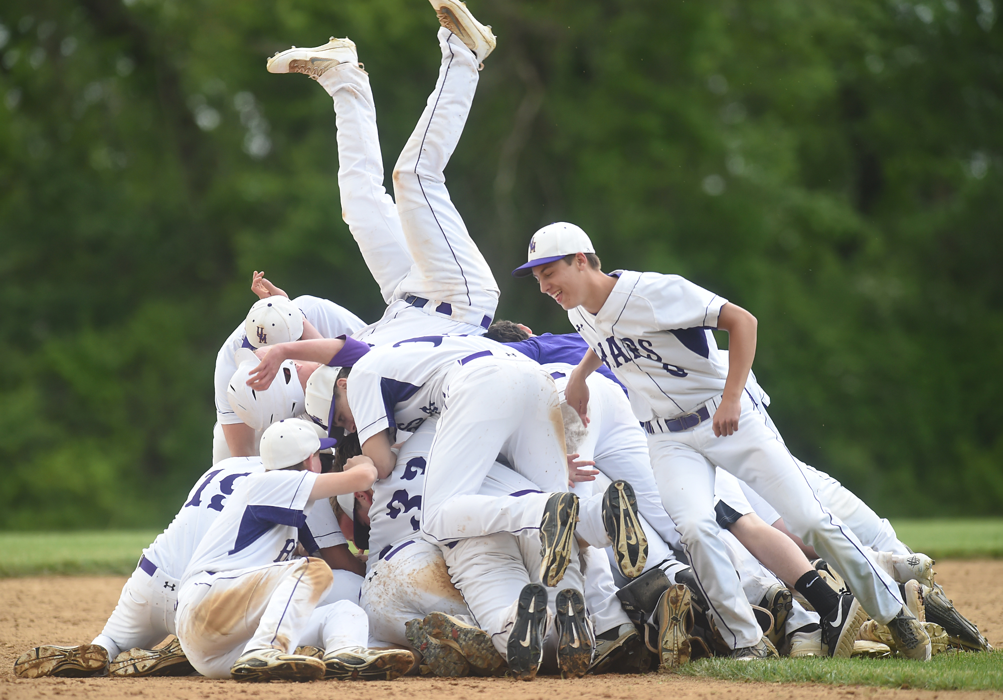  Upper Moreland players jump on top of teammate Randy Meehl (11) to celebrate after he hit a single to get a runner home in the bottom of the seventh during their game against Phoenixville in Upper Moreland./ Upper Moreland won the game 1-0. 