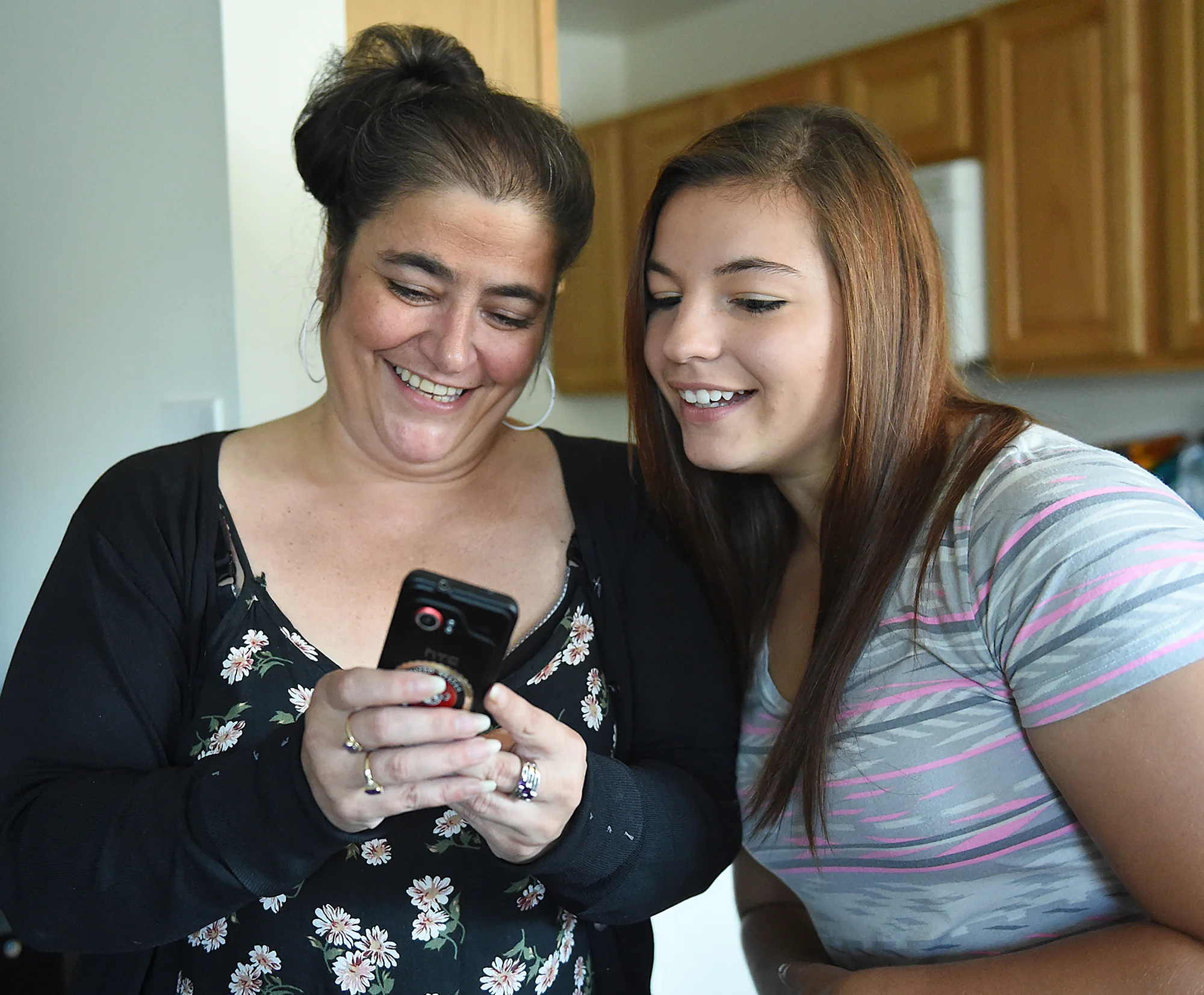 Dee Hubay looks at a picture with her mom Andrea Roberto during a party at their apartment in Northeast Philadelphia before Dee left for boot camp on Sunday, August 23, 2015. Roberto has a Marine Corps sticker on the back of her phone. 