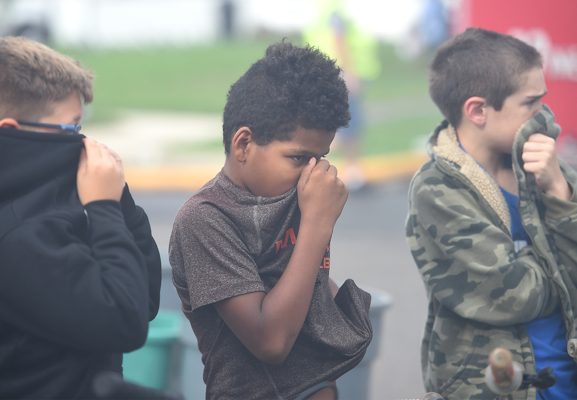  Cobalt Ridge neightborhood friends (from left) Vincent Ireland, 10, Tyreek Ross, 10, and Thomas Vlassenko, 10, hold their noses as smoke pours over them while firemen work on a fire in a home on Canoe Birch Road in the Cobalt Ridge section of Levitt