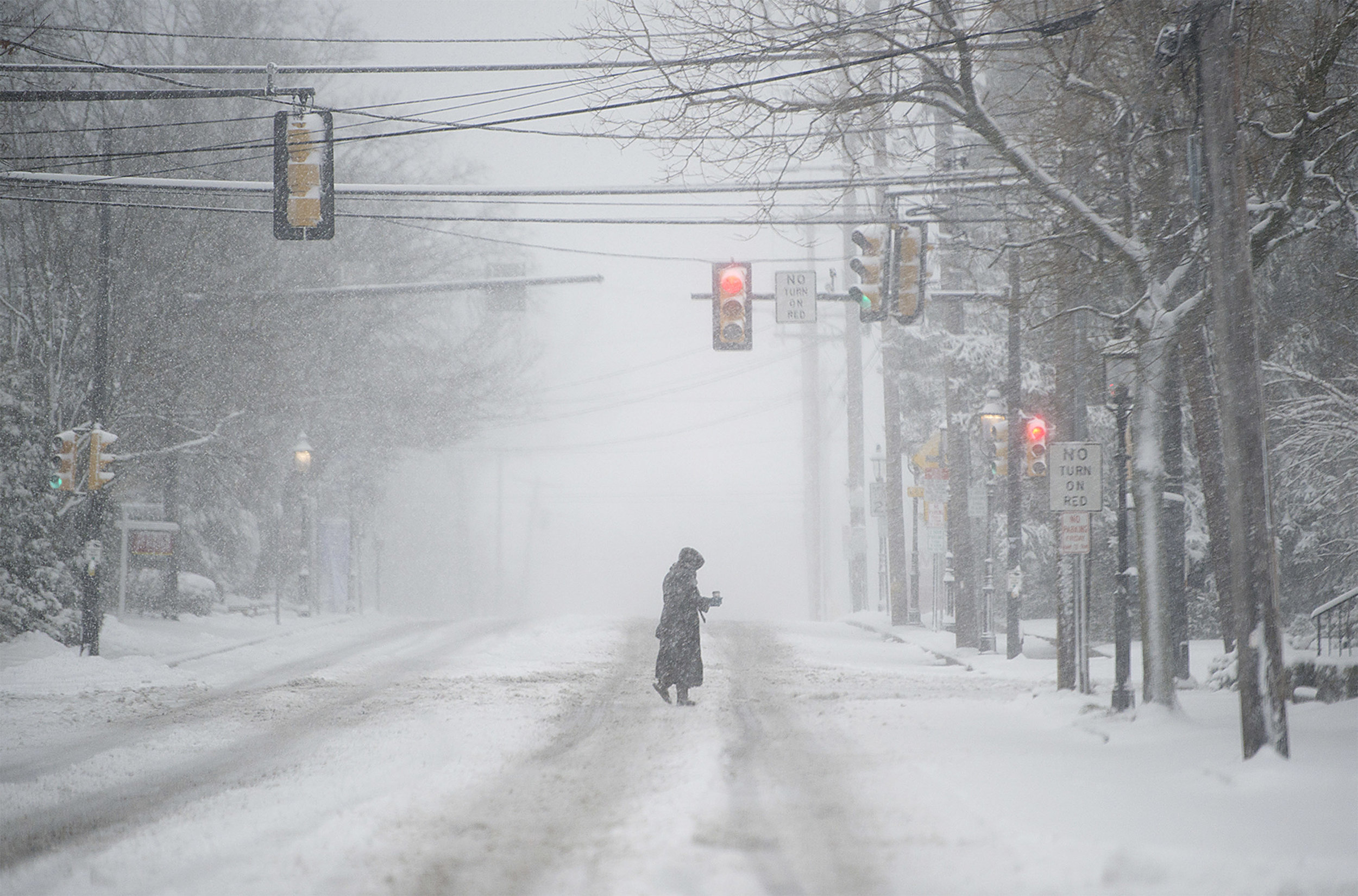  A woman crosses West State Street in Doylestown during a morning snowfall. Many area schools and businesses were closed because of the snowfall, leaving the street wide open to pedestrians. 