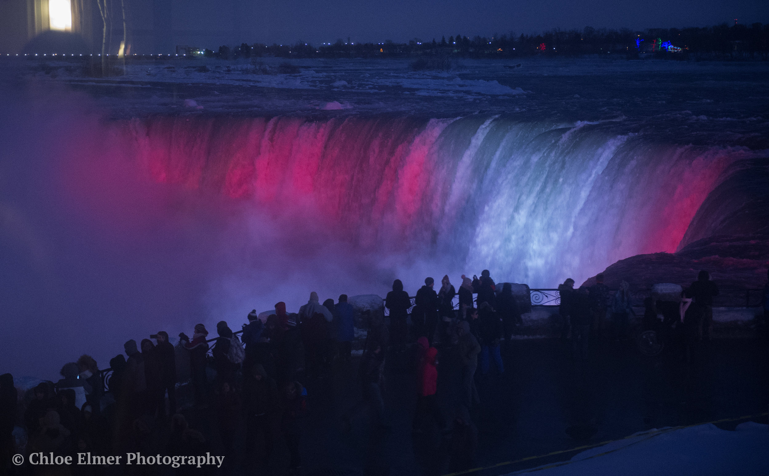 Falls at night. Niagara was red and white for Canada, New York was red, white and blue for USA.