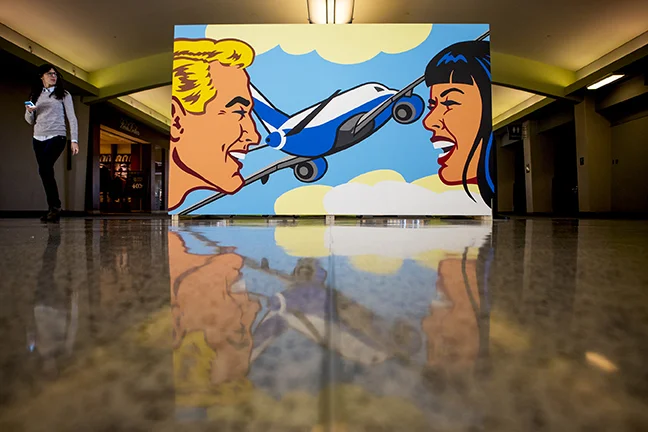 A woman walks by one of the two "Love is in the Air" murals in Concourse B of Cincinnati/Northern Kentucky International Airport Tuesday. Photo by Meg Vogel, The Cincinnati Enquirer