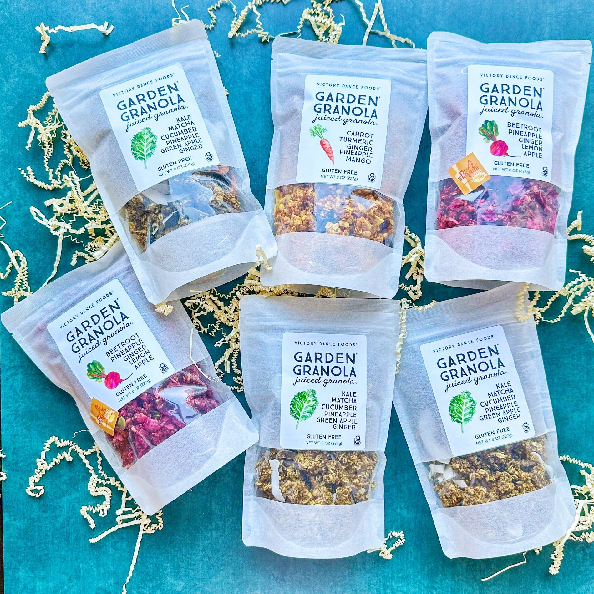 Six bags of Victory Dance Foods Garden Granola in assorted flavors with crinkle cut paper.