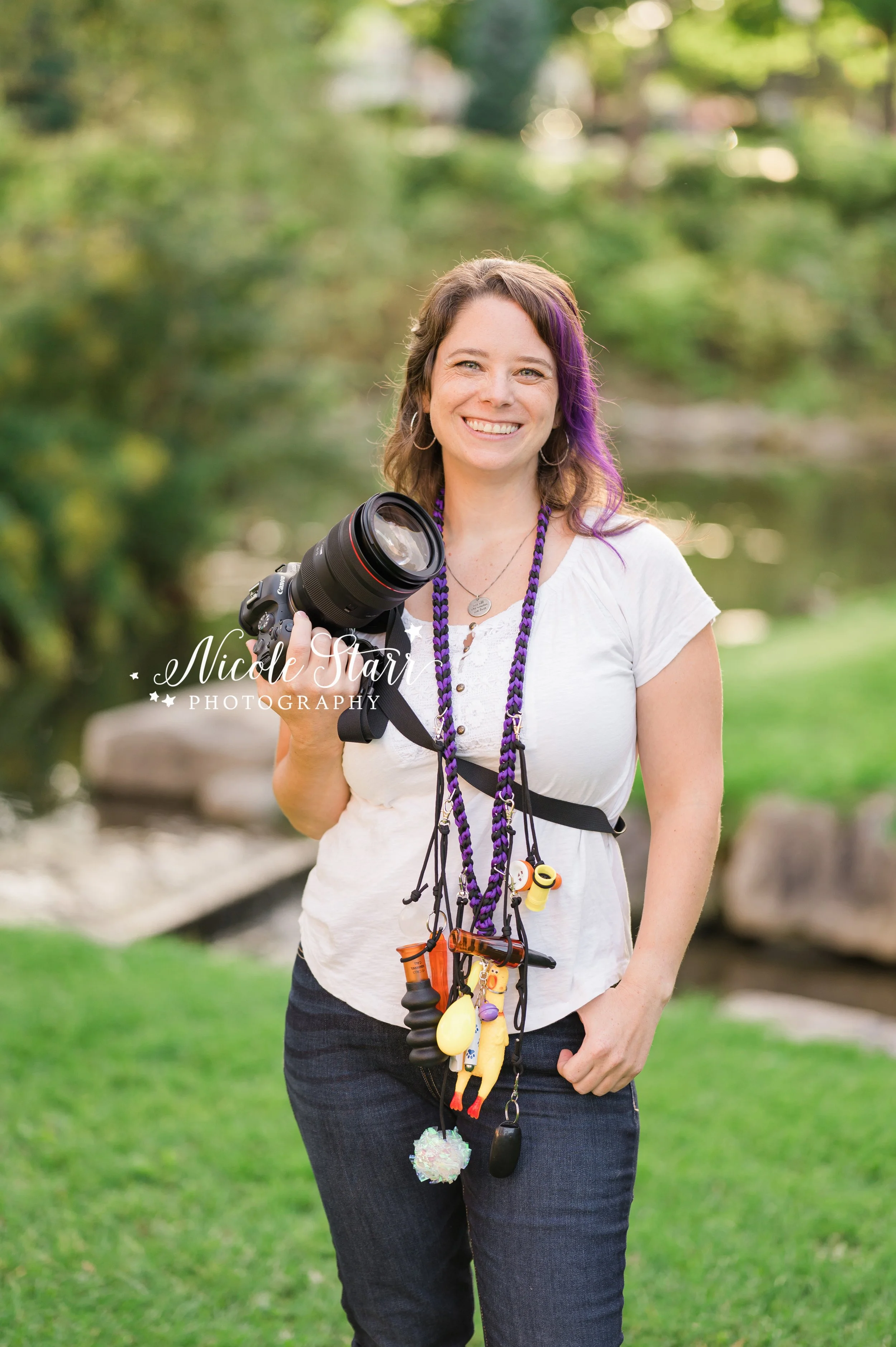 pet photographer poses with camera and dog toys during branding session with Nicole Starr Photography, Saratoga Springs branding photographer