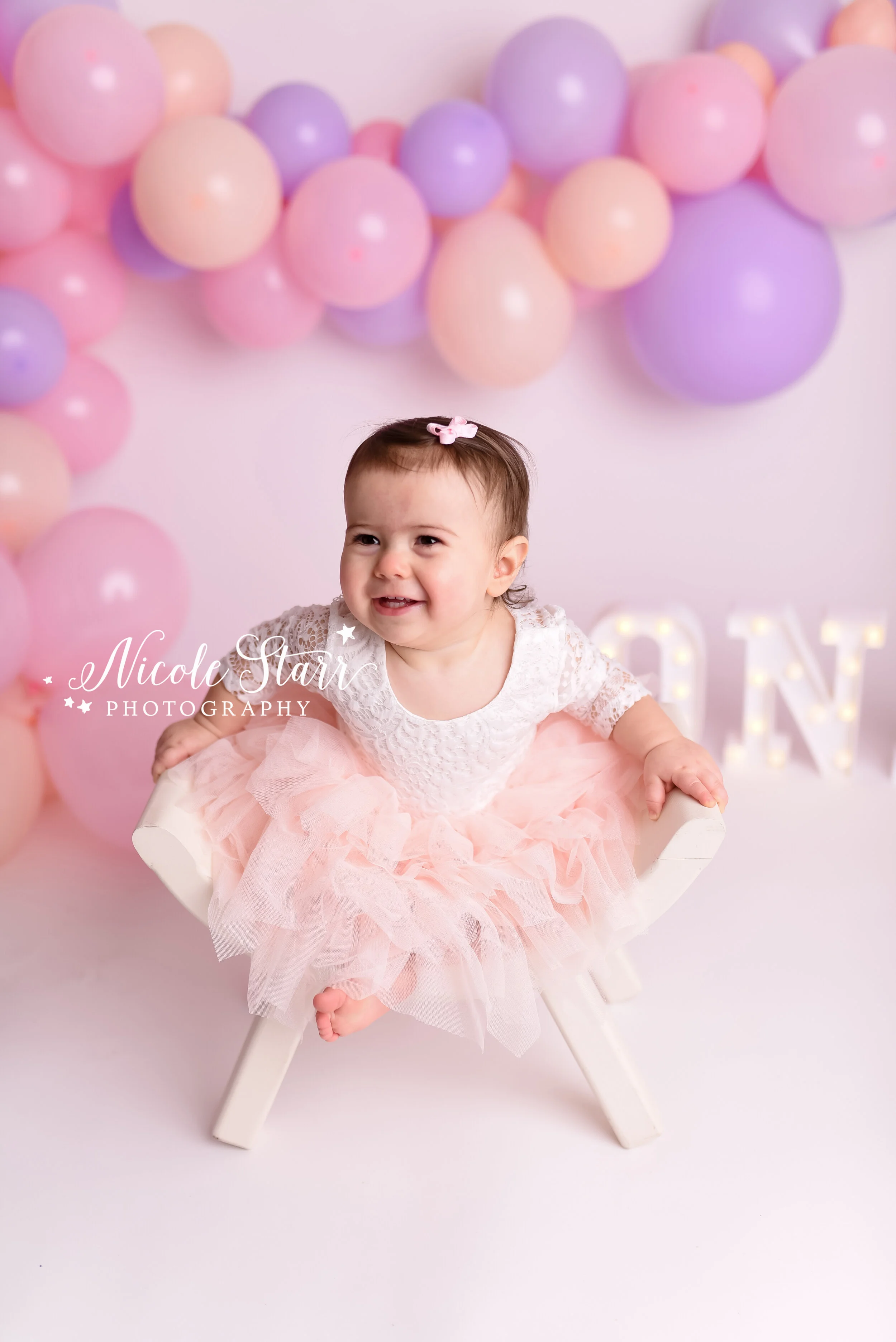 Pink, purple, and peach cake smash with balloon garland by Nicole Starr Photography | Saratoga Springs Cake Smash Photographer | Boston Cake Smash Photographer | Saratoga Springs Family Photographer | Boston Family Photographer Delmar NY Cake Smash …