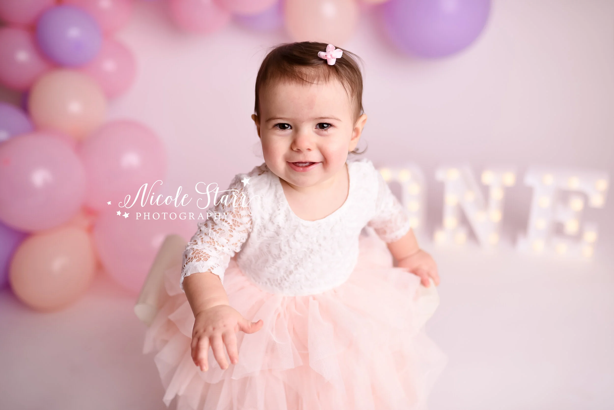Pink, purple, and peach cake smash with balloon garland by Nicole Starr Photography | Saratoga Springs Cake Smash Photographer | Boston Cake Smash Photographer | Saratoga Springs Family Photographer | Boston Family Photographer Delmar NY Cake Smash …