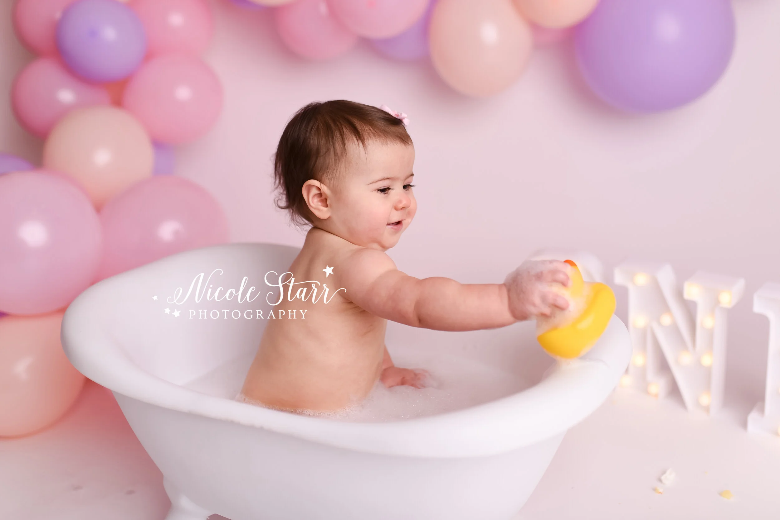 Pink, purple, and peach cake smash with balloon garland by Nicole Starr Photography | Saratoga Springs Cake Smash Photographer | Boston Cake Smash Photographer | Saratoga Springs Family Photographer | Boston Family Photographer Delmar NY Cake Smash …