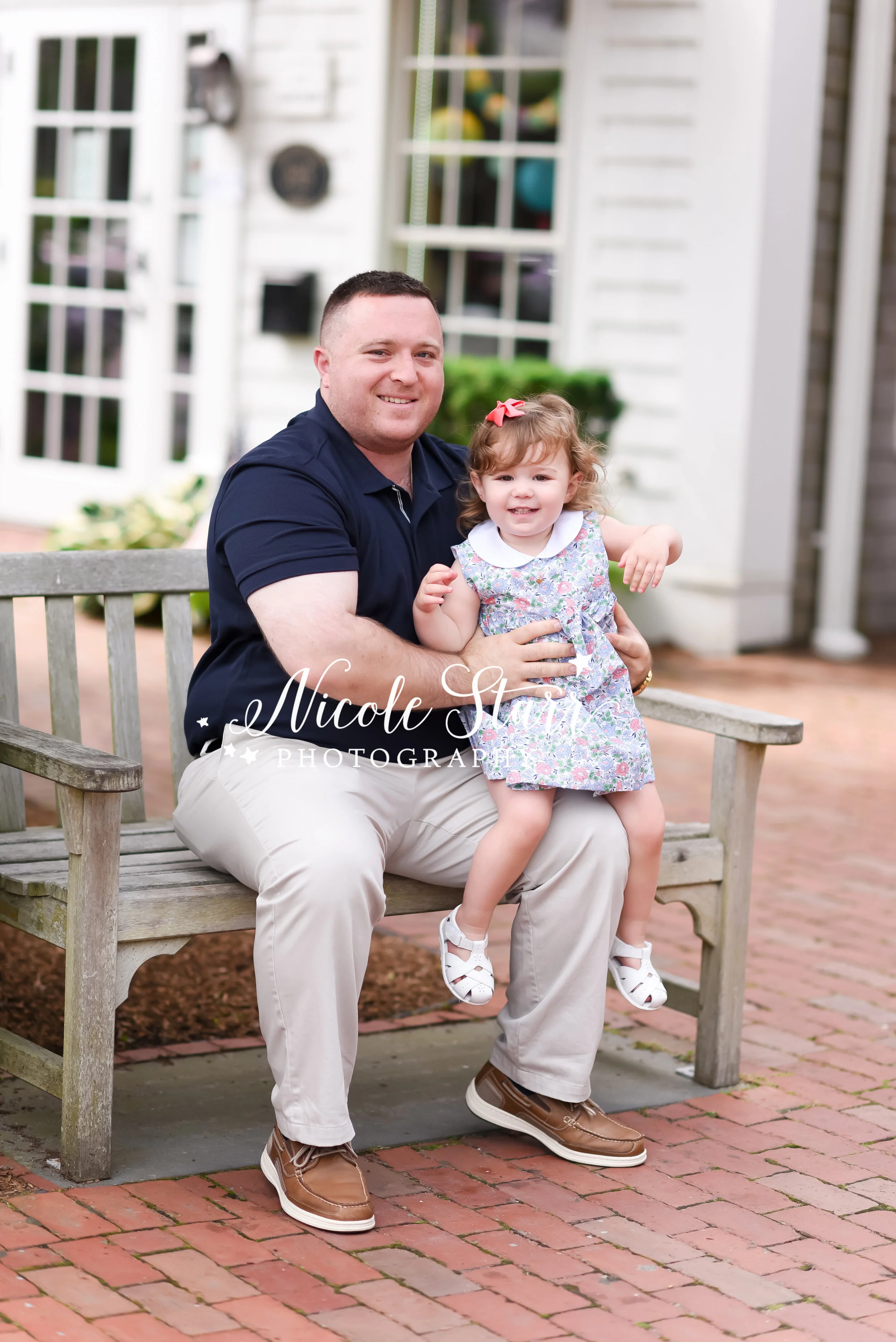 dad sits with daughter during portraits in Downtown Chatham photographed by Cape Cod family and beach photographer Nicole Starr Photography | Classic Cape Cod portraits