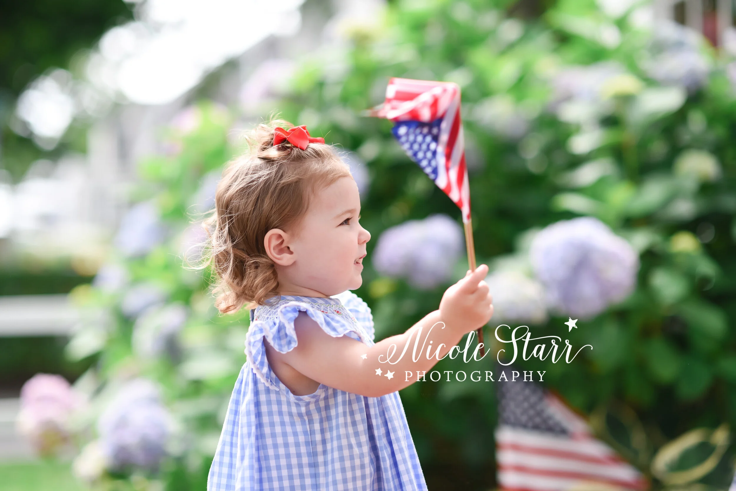 little girl waves American flag during portraits photographed by Cape Cod family and beach photographer Nicole Starr Photography | Classic Cape Cod portraits