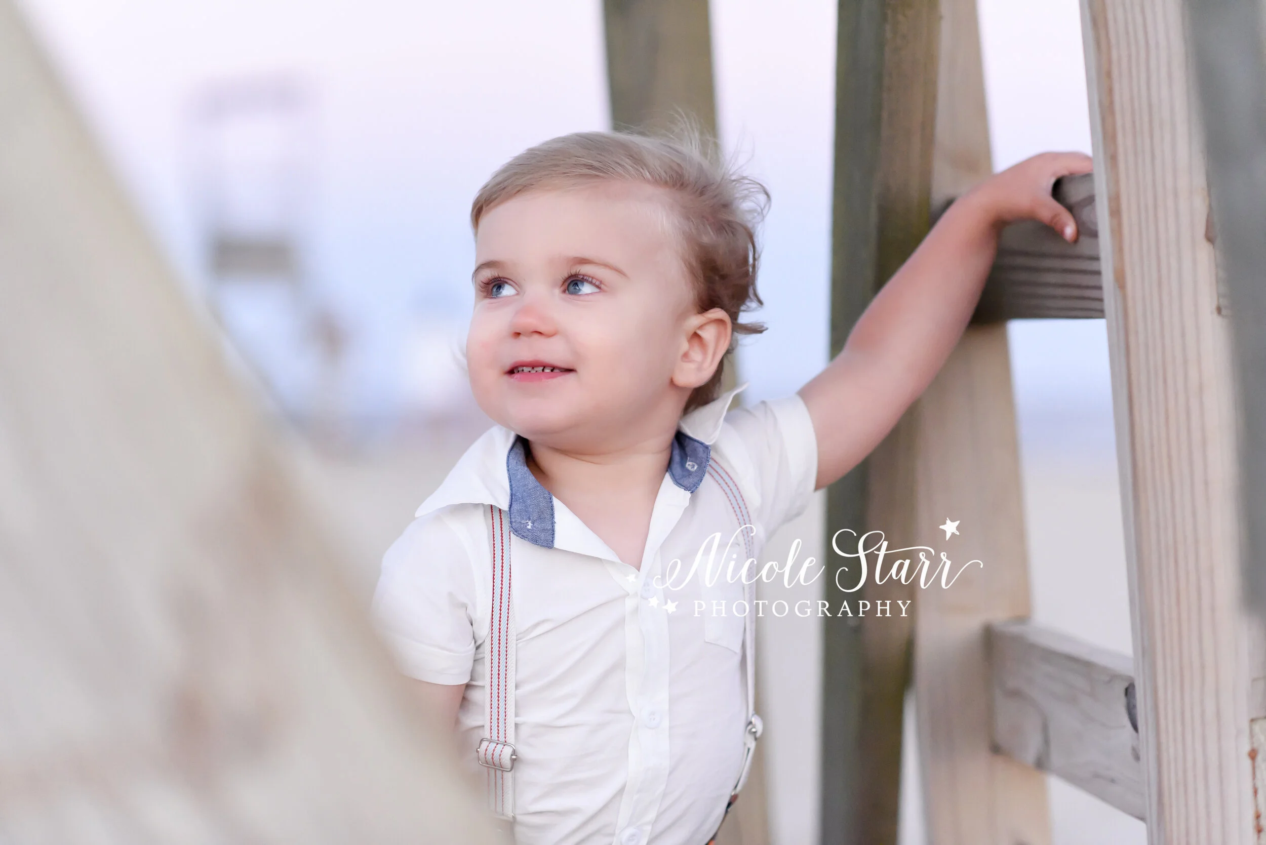 portraits of young boy on by lifeguard stand on Cape Cod beach photographed by Cape Cod family photographer Nicole Starr Photography