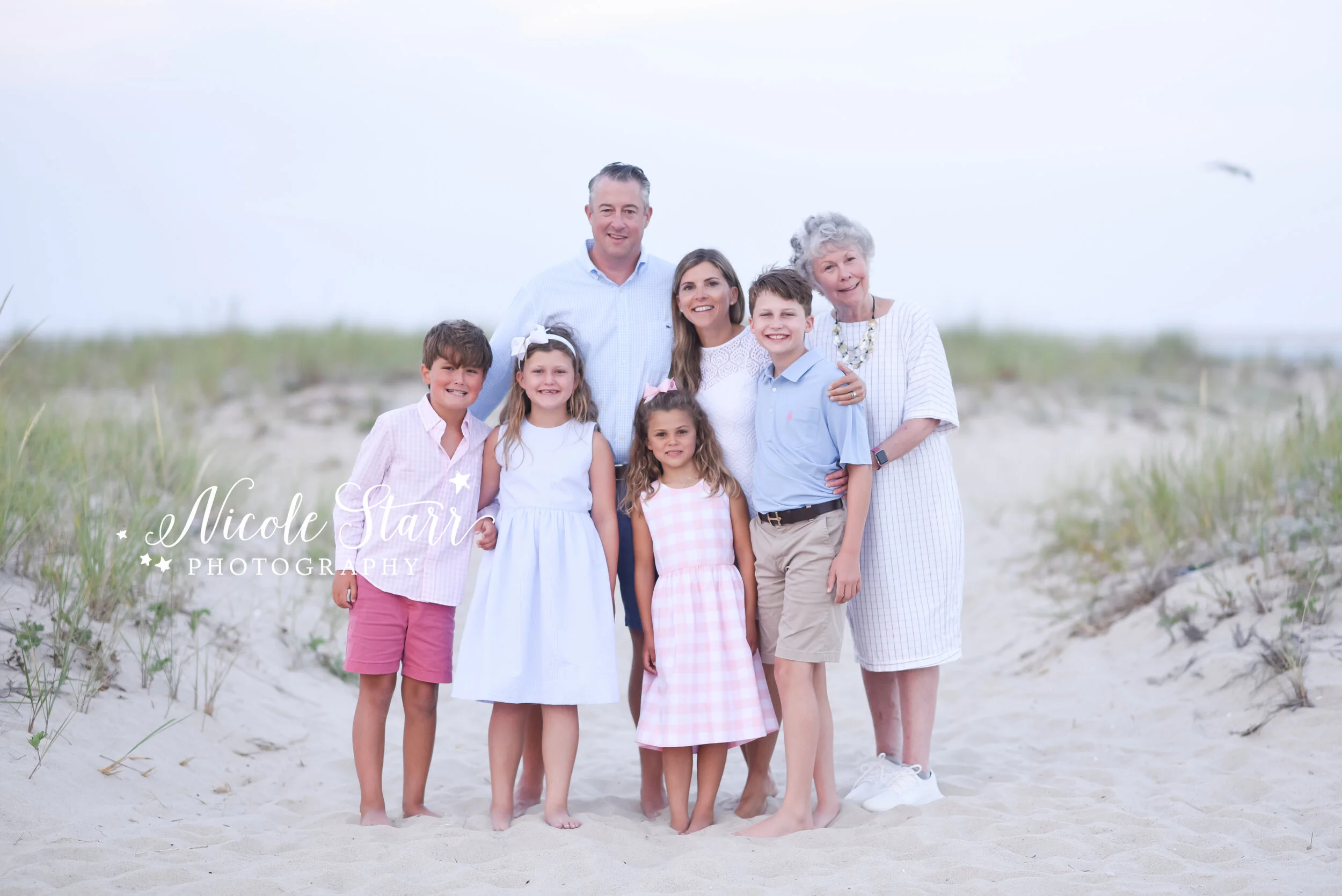 family poses on beach with grandmother photographed by Cape Cod family photographer Nicole STarr Photography