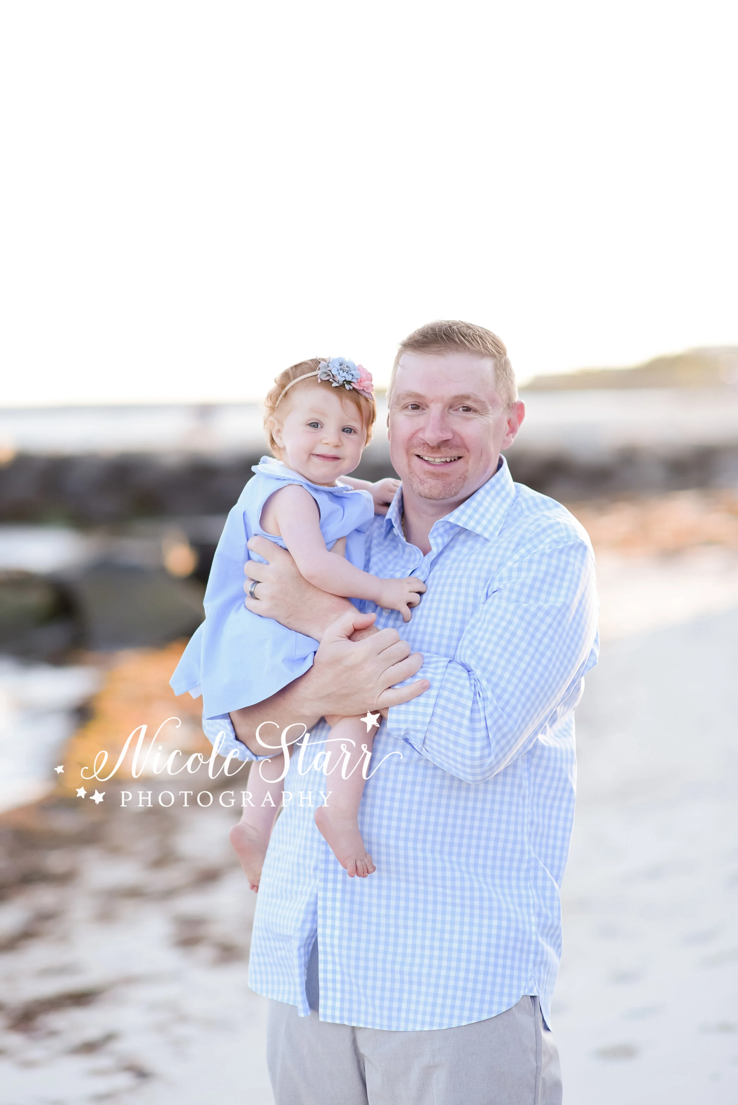 dad poses with birthday girl on beach during family photos with Cape Cod beach family photographer Nicole Starr Photography