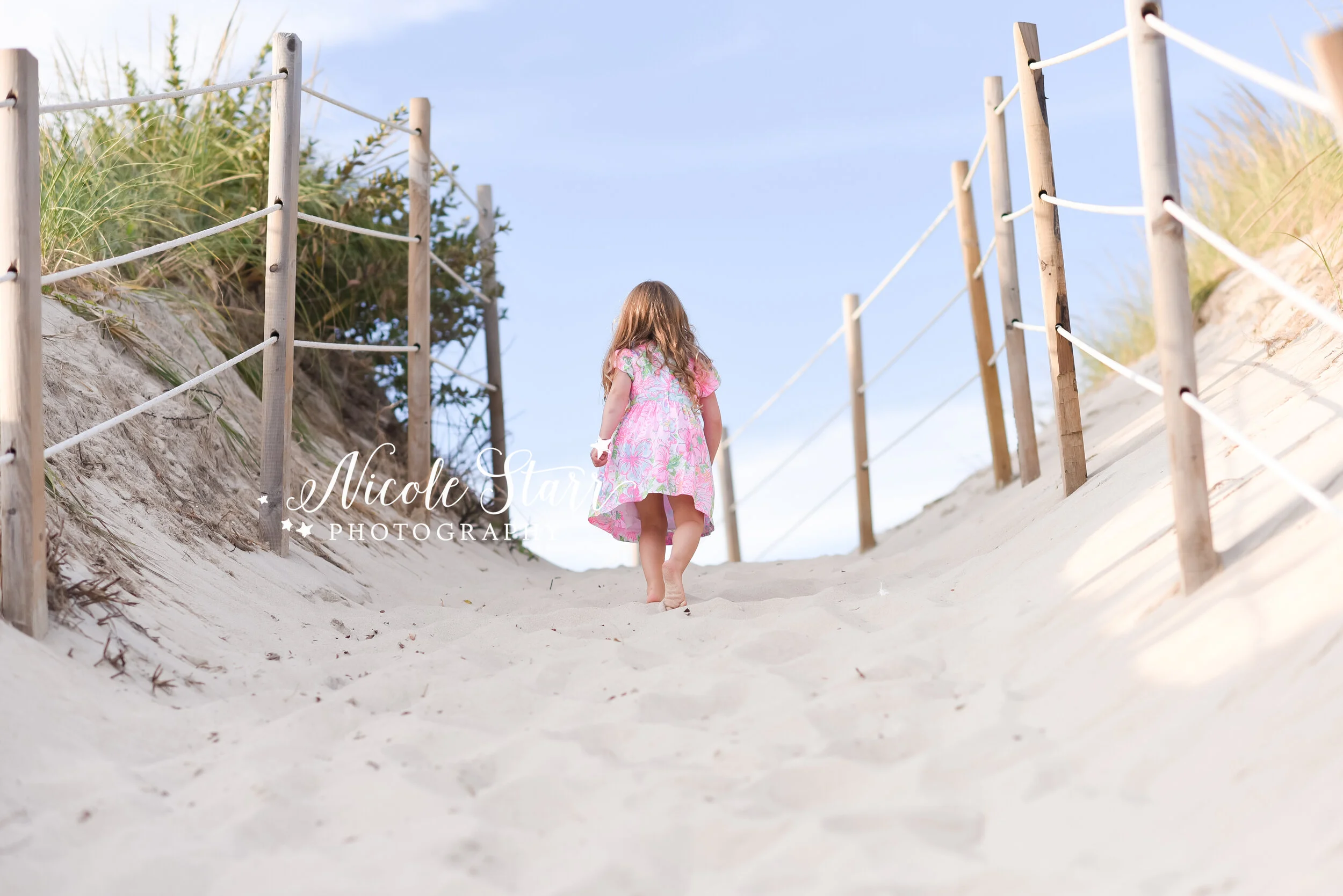 toddler walks up sand dune in Cape Cod during family portraits in Dennis photographed by Cape Cod family photographer Nicole Starr Photography