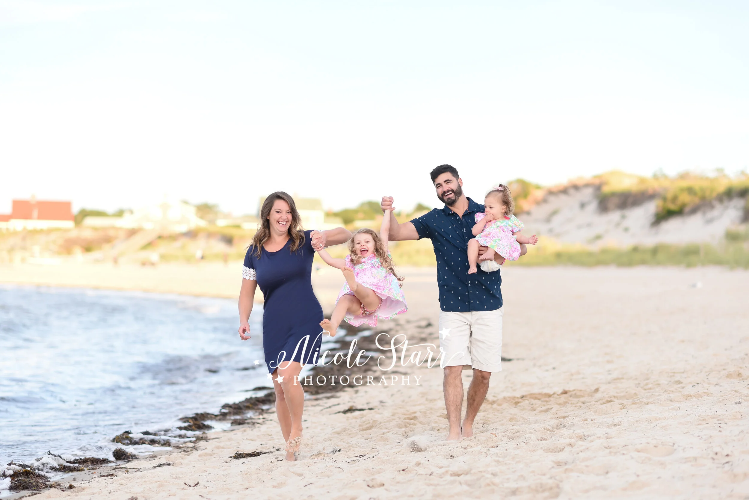 family walks along waterfront in Cape Cod photographed by MA family photographer Nicole Starr Photography