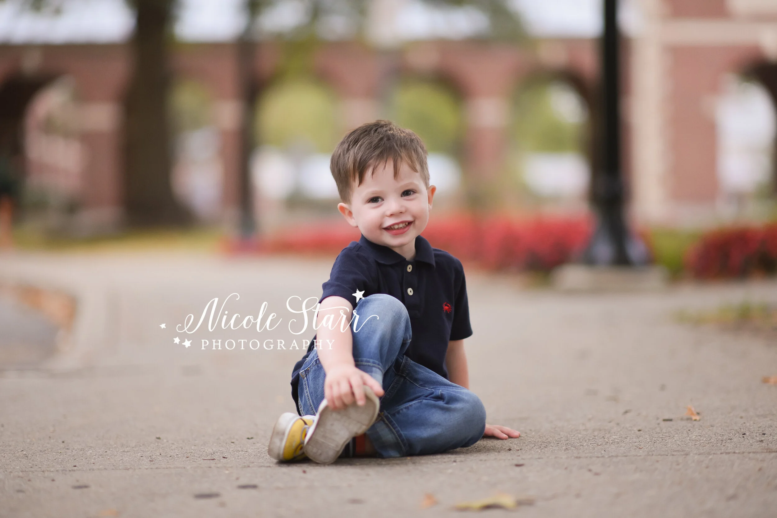 young boy sits on sidewalk during family photos with Saratoga Springs luxury portrait photographer Nicole Starr Photography