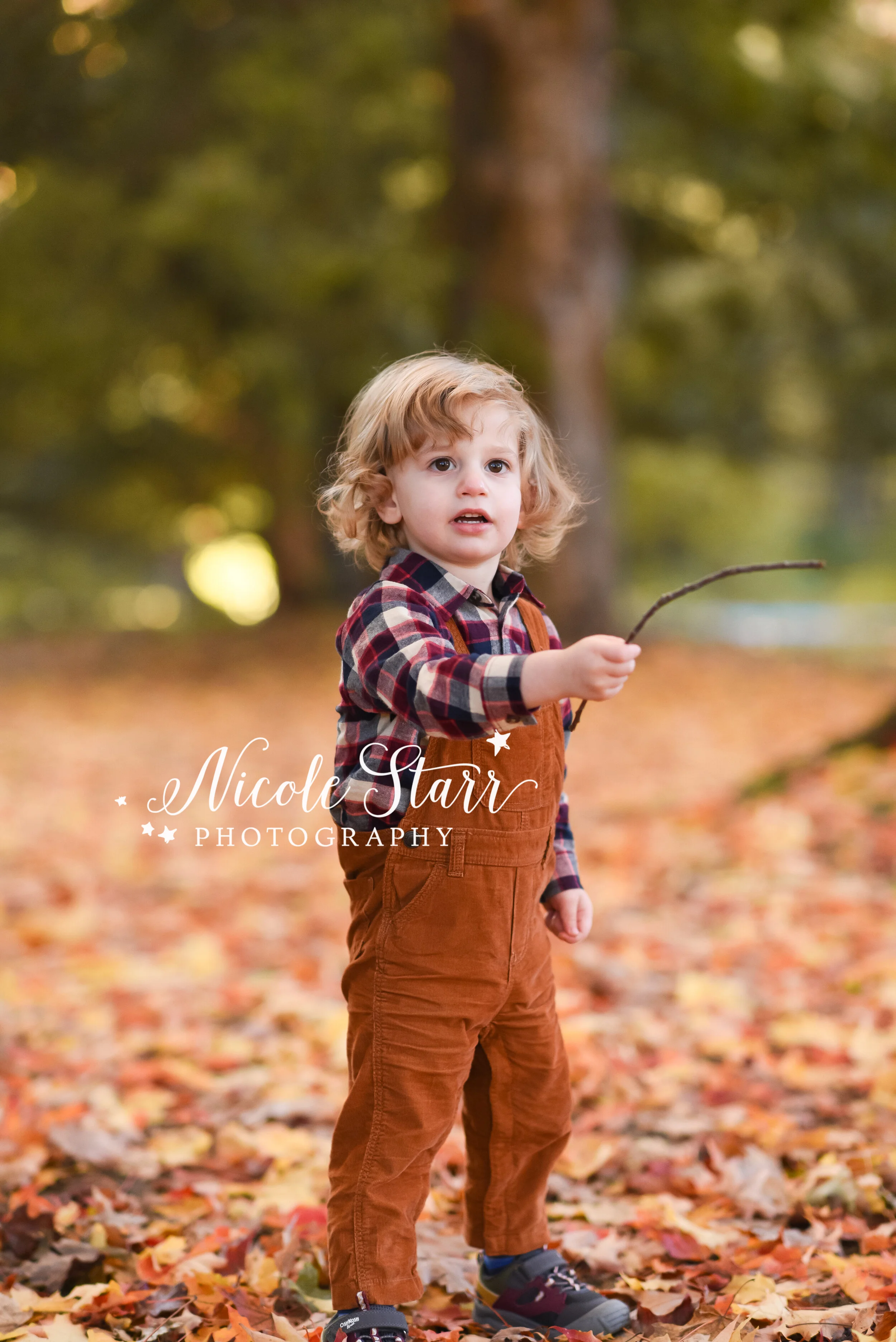 toddler throws leaves during New York family photos with family photographer Nicole Starr Photography
