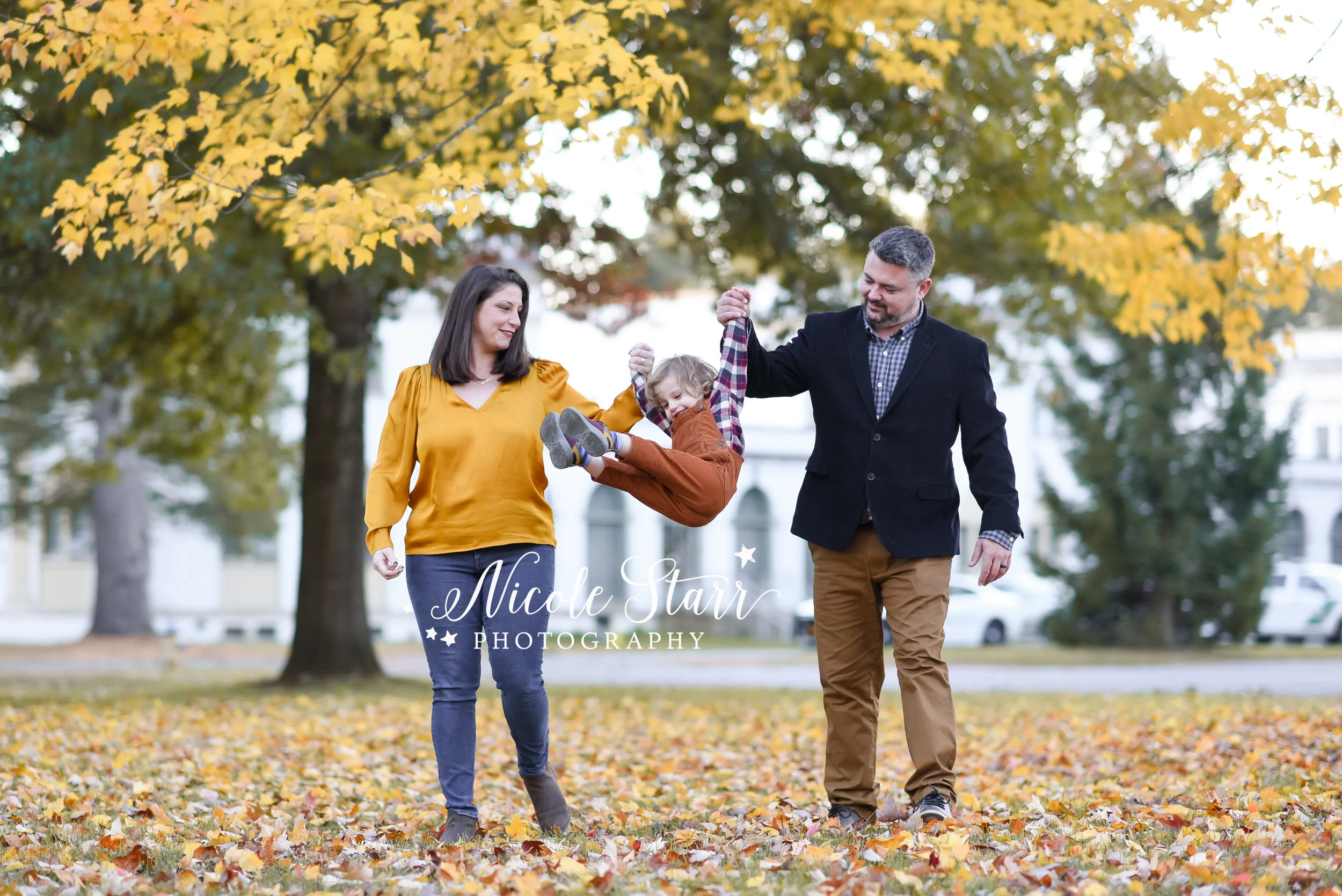 parents swing toddler during photos with Delmar NY family photographer Nicole Starr Photography