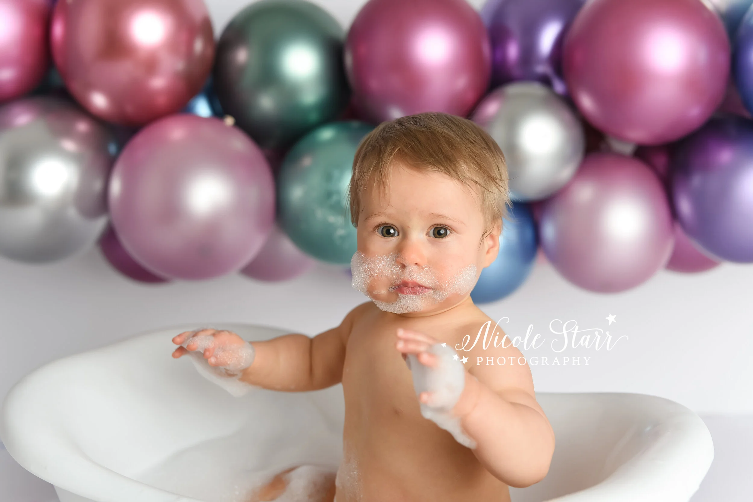 baby plays in tub after cake smash photographed by Delmar NY cake smash photographer Nicole Starr Photography