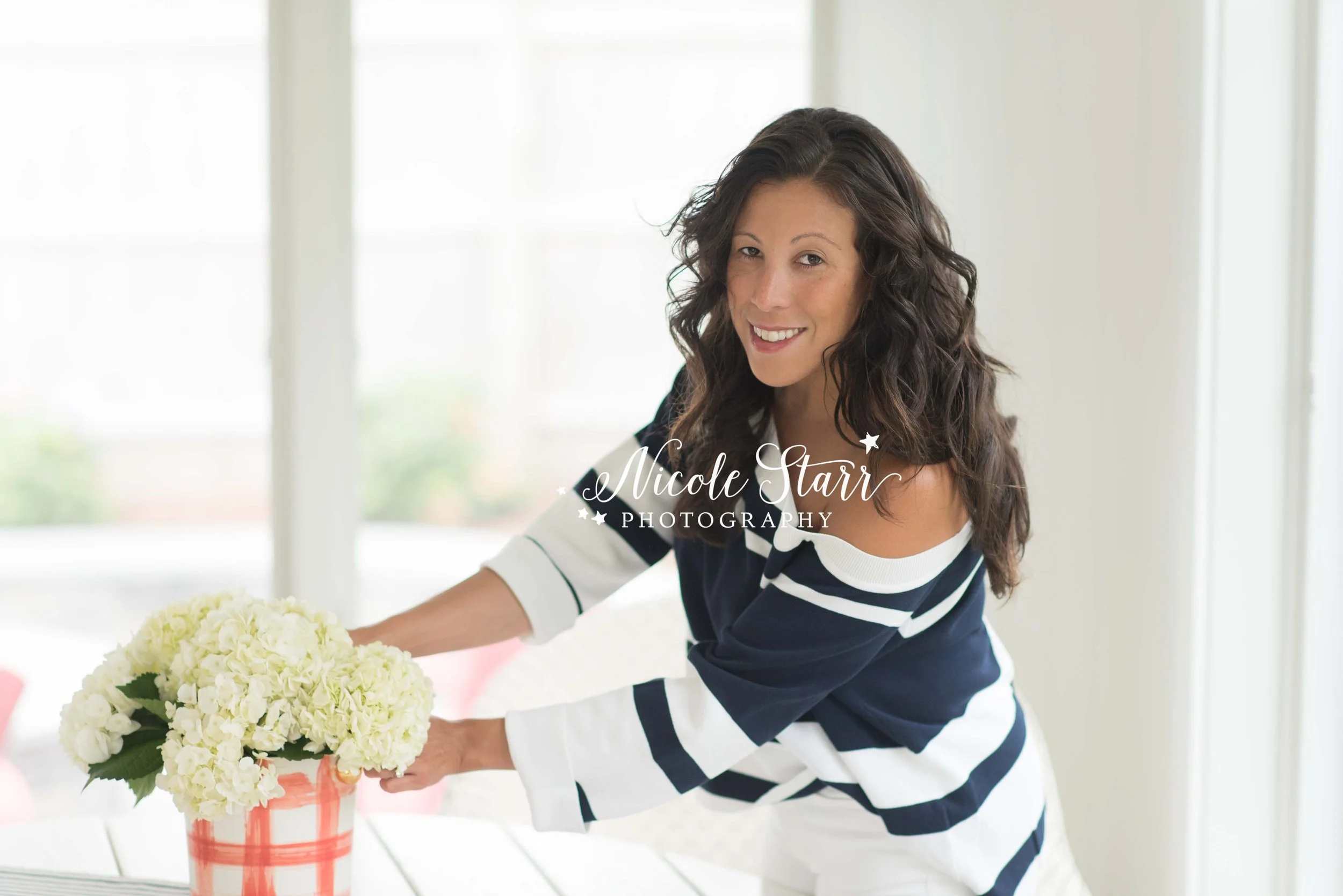 woman arranges flowers in navy and white shirt during headshots with Saratoga Springs headshot photographer Nicole Starr Photography