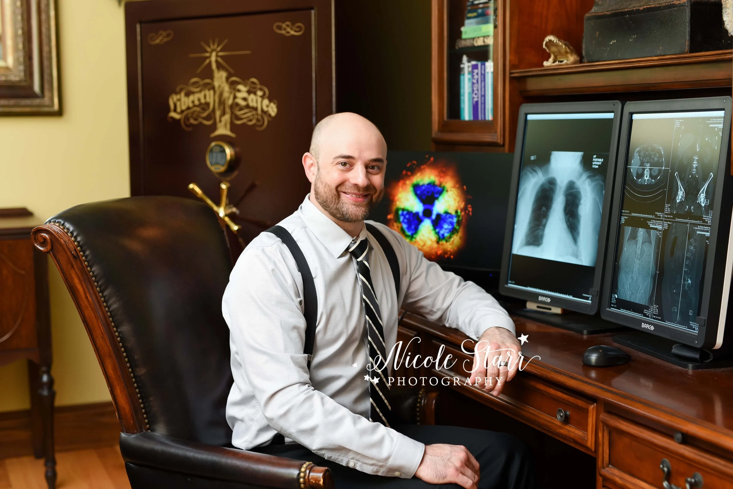 man sits at desk during medical headshots for doctor photographed by Saratoga Springs NY headshot photographer Nicole Starr Photography