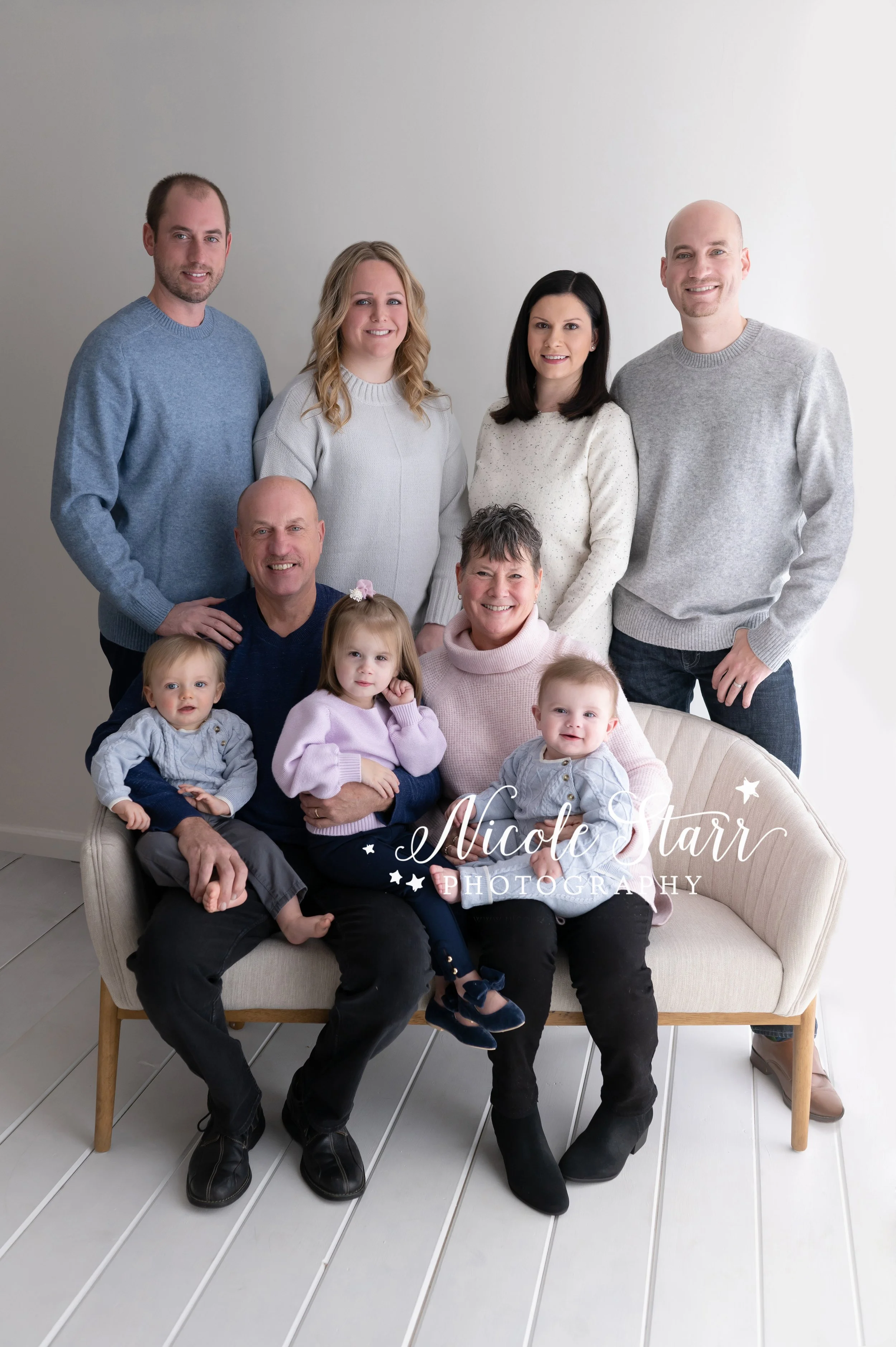 parents pose with four adults and three children during extended family portraits in studio photographed by Saratoga Springs NY family photographer Nicole Starr Photography