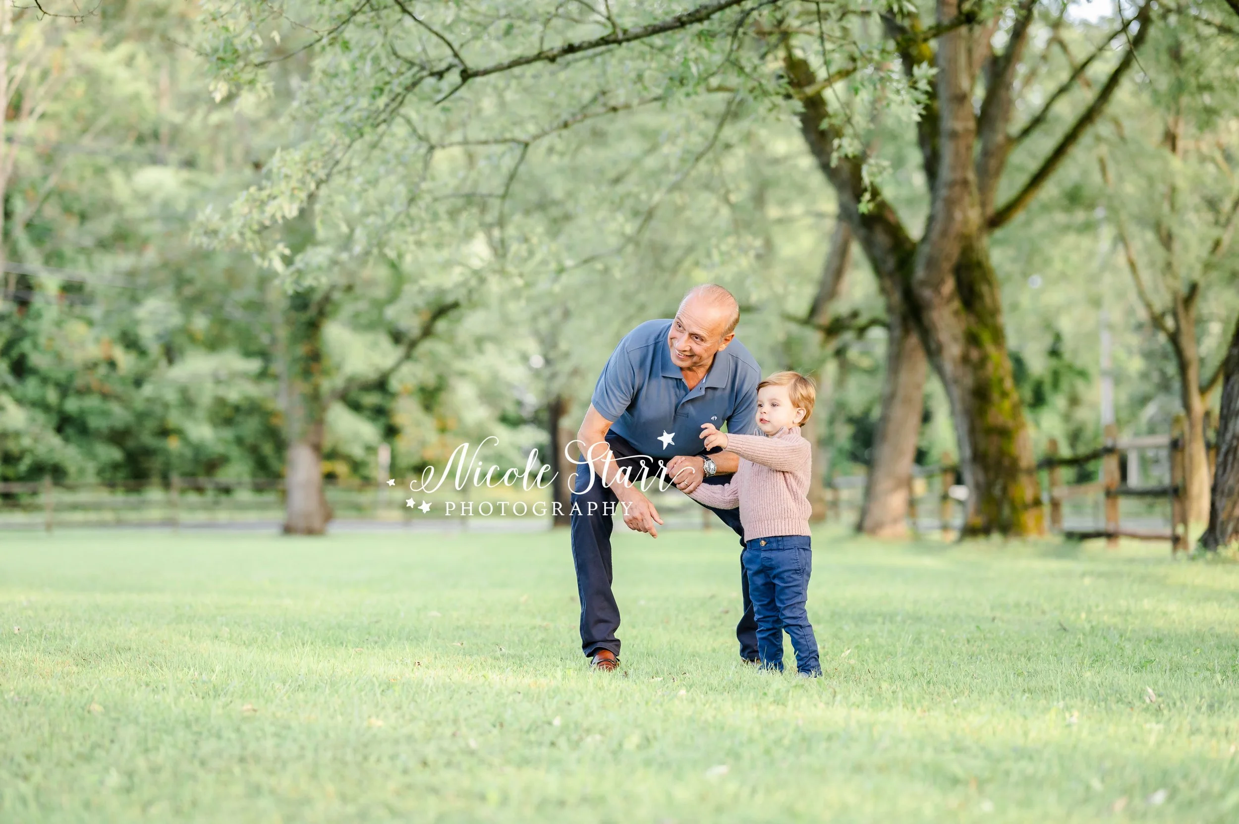 toddler boy plays with grandfather in park during generational family portrait session with Saratoga Springs NY family photographer Nicole Starr Photography