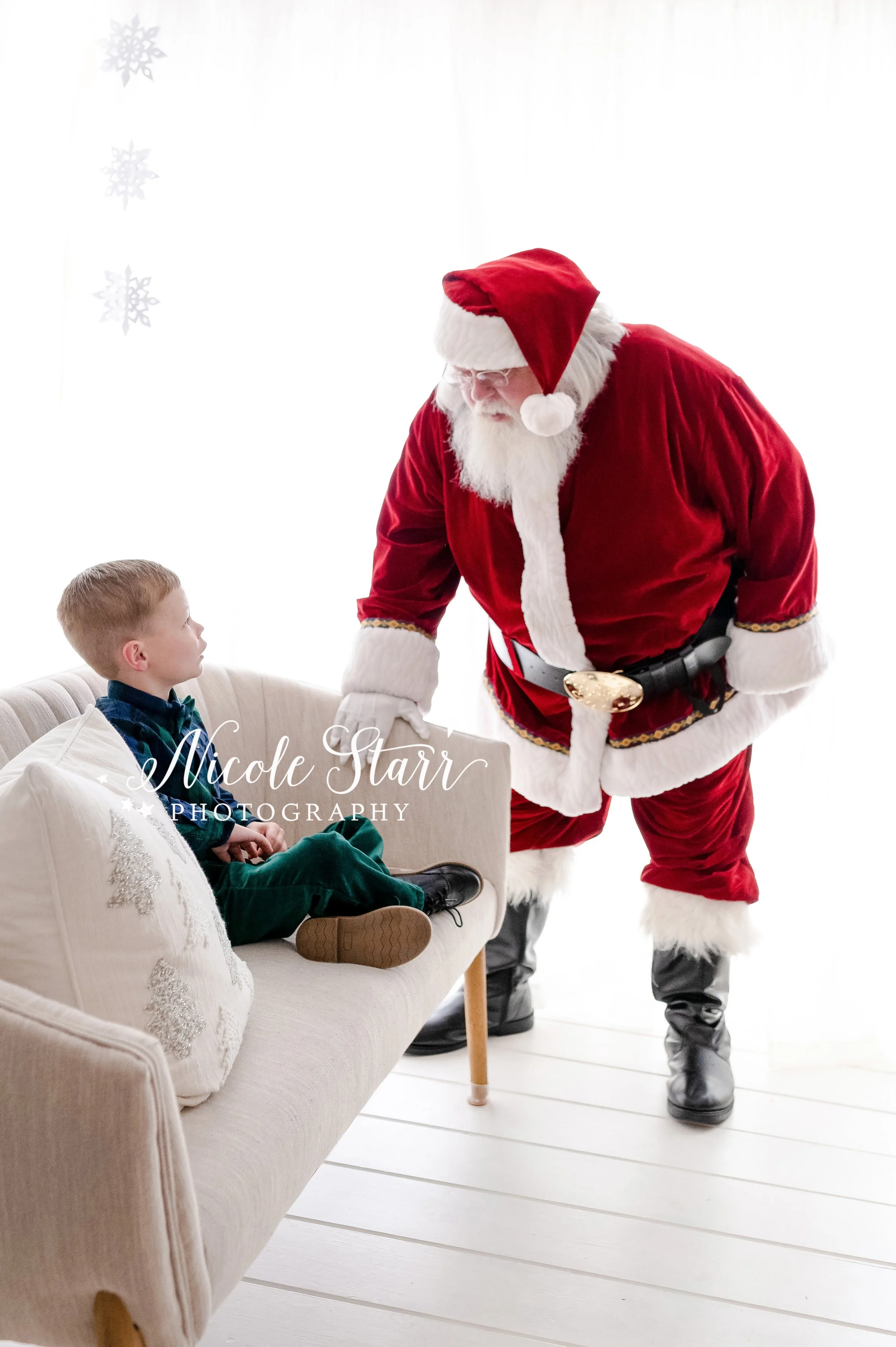 Santa talks to boy in green and blue plaid shirt during Saratoga Springs holiday studio session with Santa Claus photographed by NY children’s photographer Nicole Starr Photography