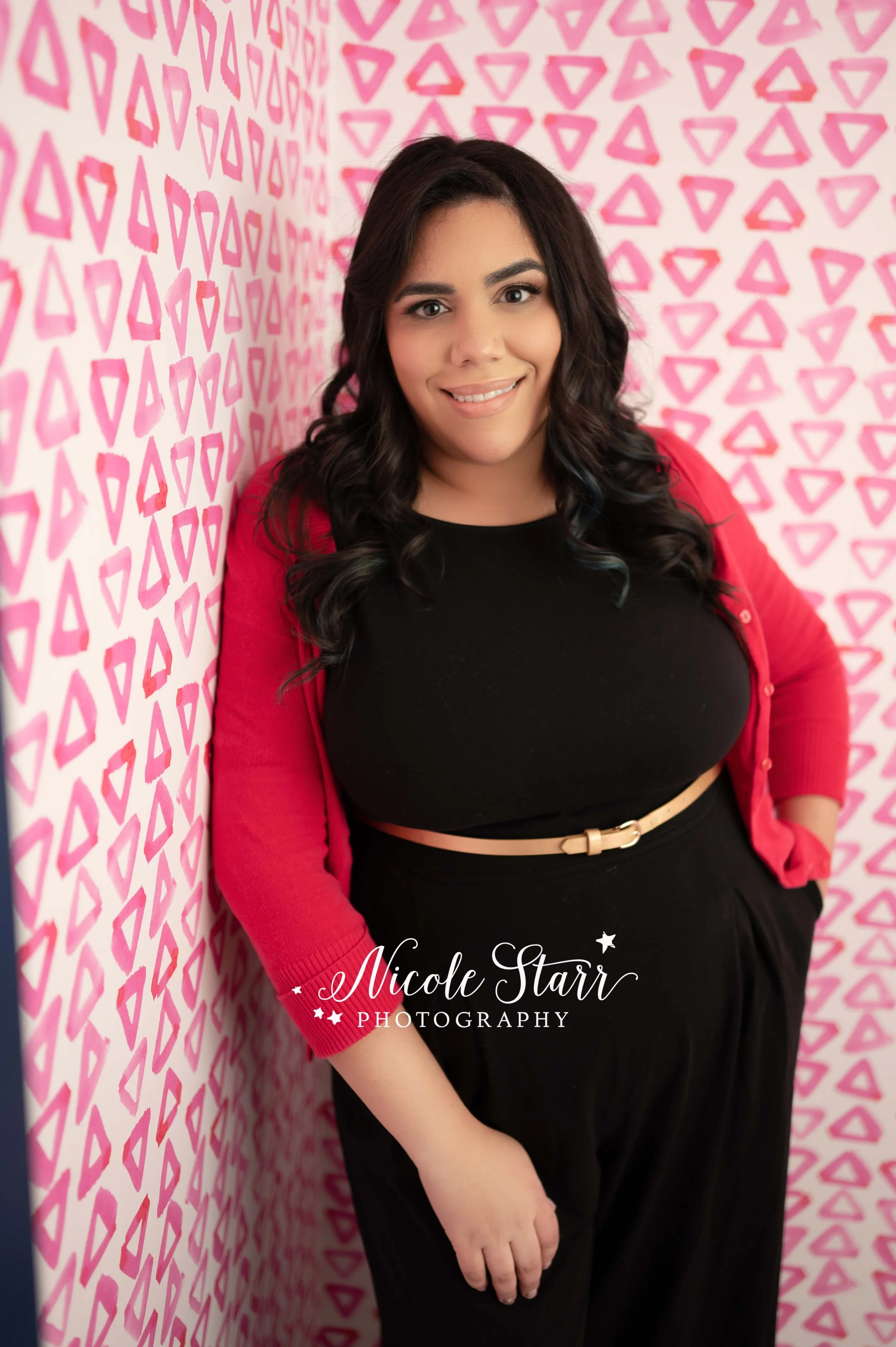 woman leans against pink wall at Palette Community during headshots with NY headshot photographer Nicole Starr Photography