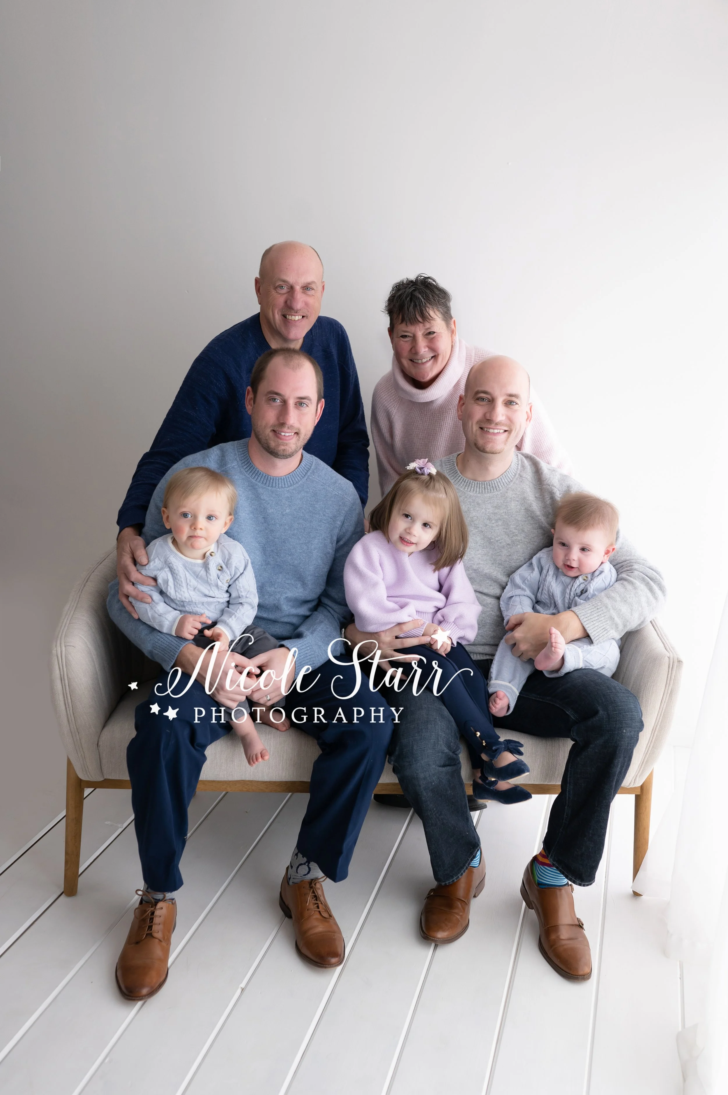 grandparents pose with sons and their children during family portraits in studio with Saratoga Springs NY family photographer Nicole Starr Photography