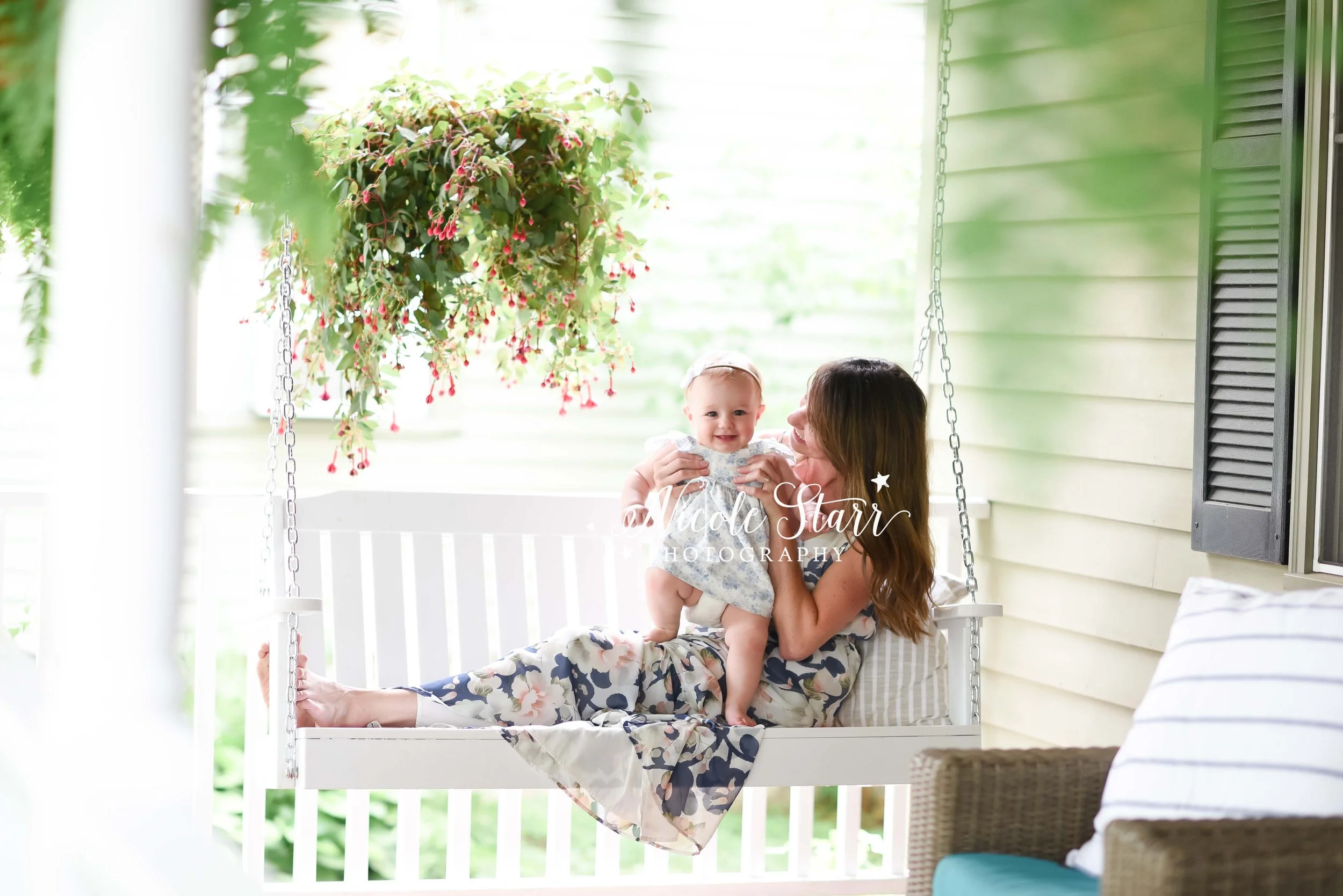 mom sits on white swing with daughter at home during spring photos with Saratoga Springs NY family photographer Nicole Starr Photography