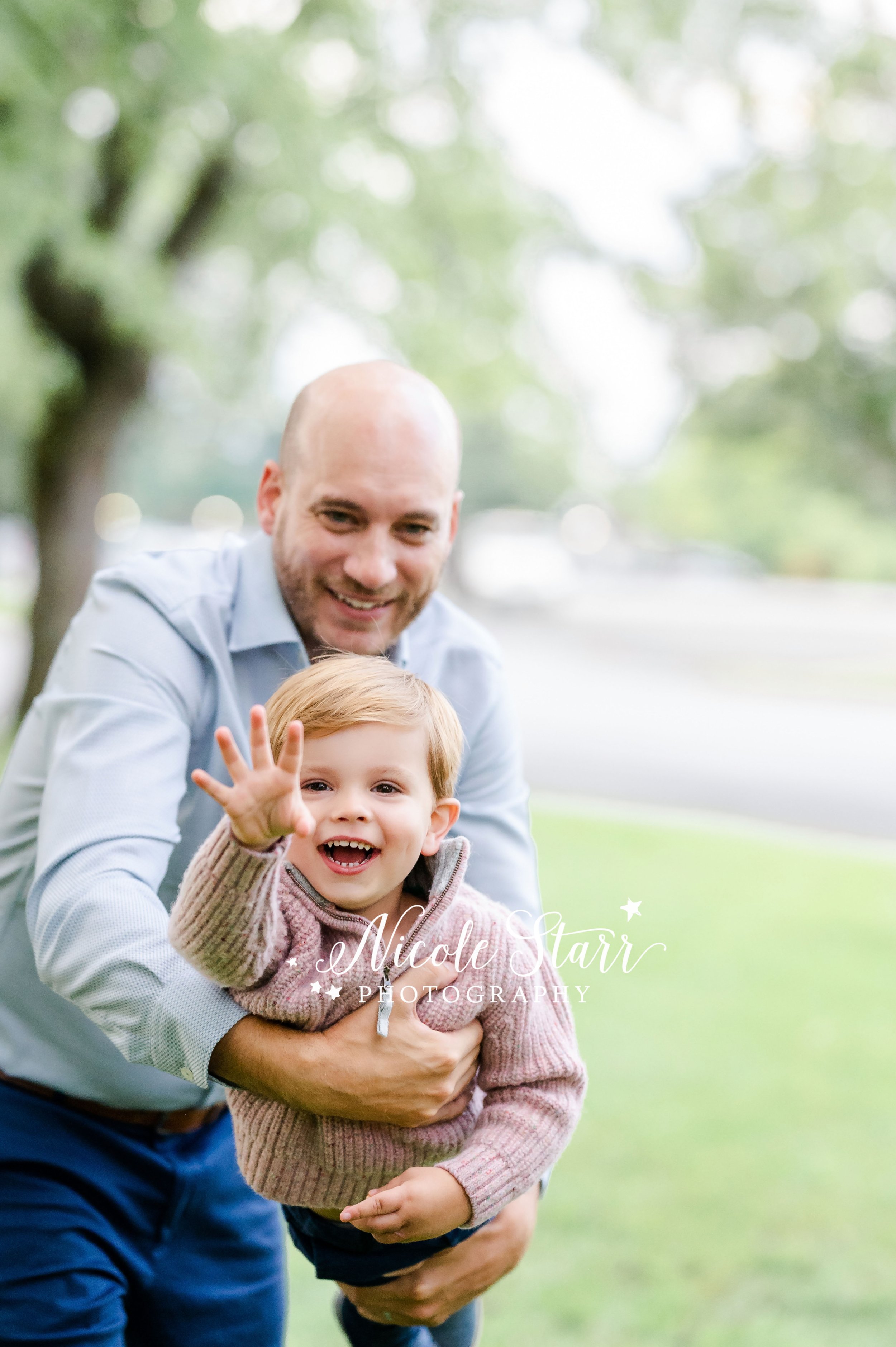 dad plays with  son making him laugh and wave during generational family portraits with Saratoga Springs NY family photographer Nicole Starr Photography