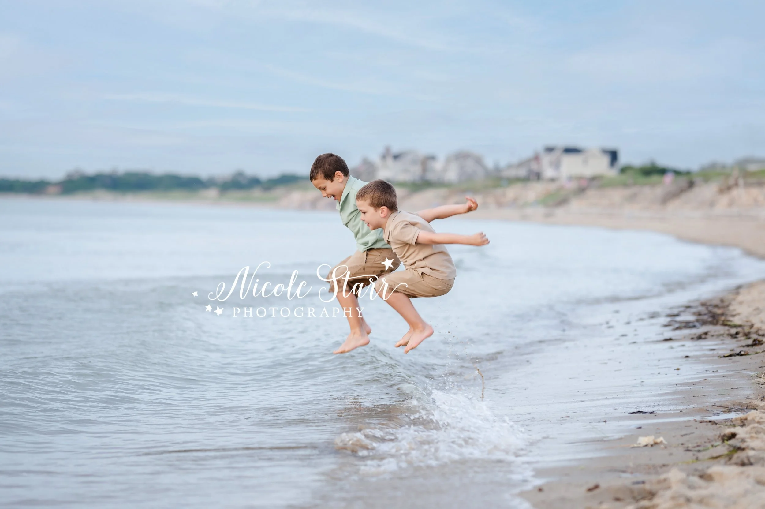 boys jump in to ocean during summer family portraits with MA beach photographer Nicole Starr Photography