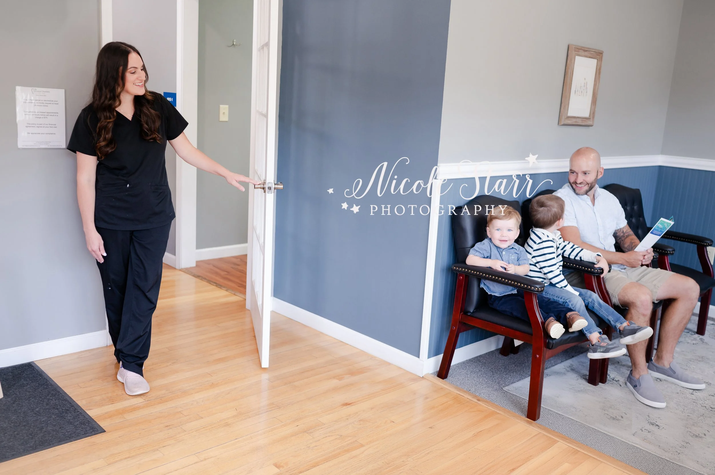 dental hygienist welcomes father and two sons in lobby during branding session in dental office photographed by Clifton Park branding photographer Nicole Starr Photography