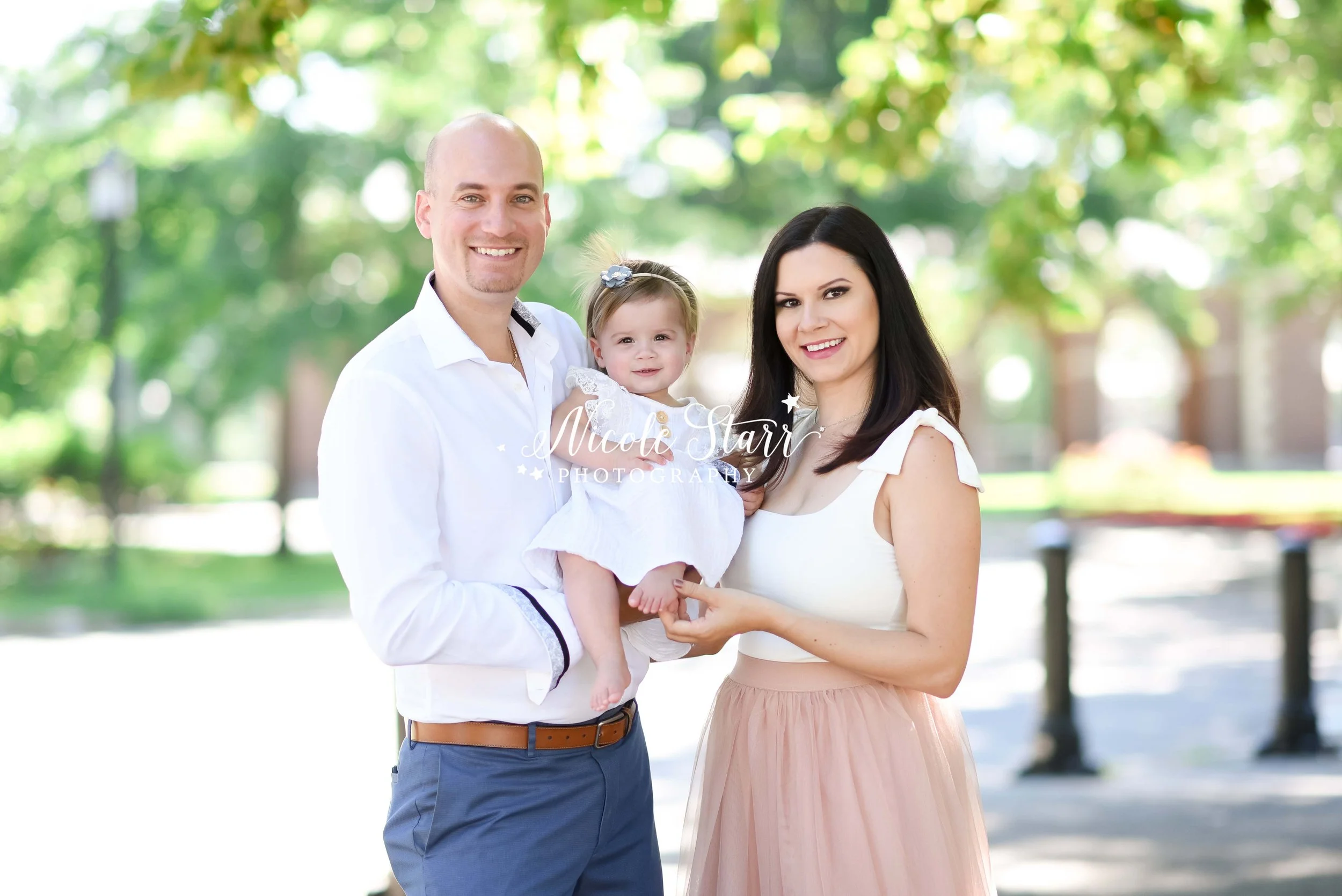 parents pose with little girl in white dress during spring family photos in Saratoga Springs NY with Nicole Starr Photography
