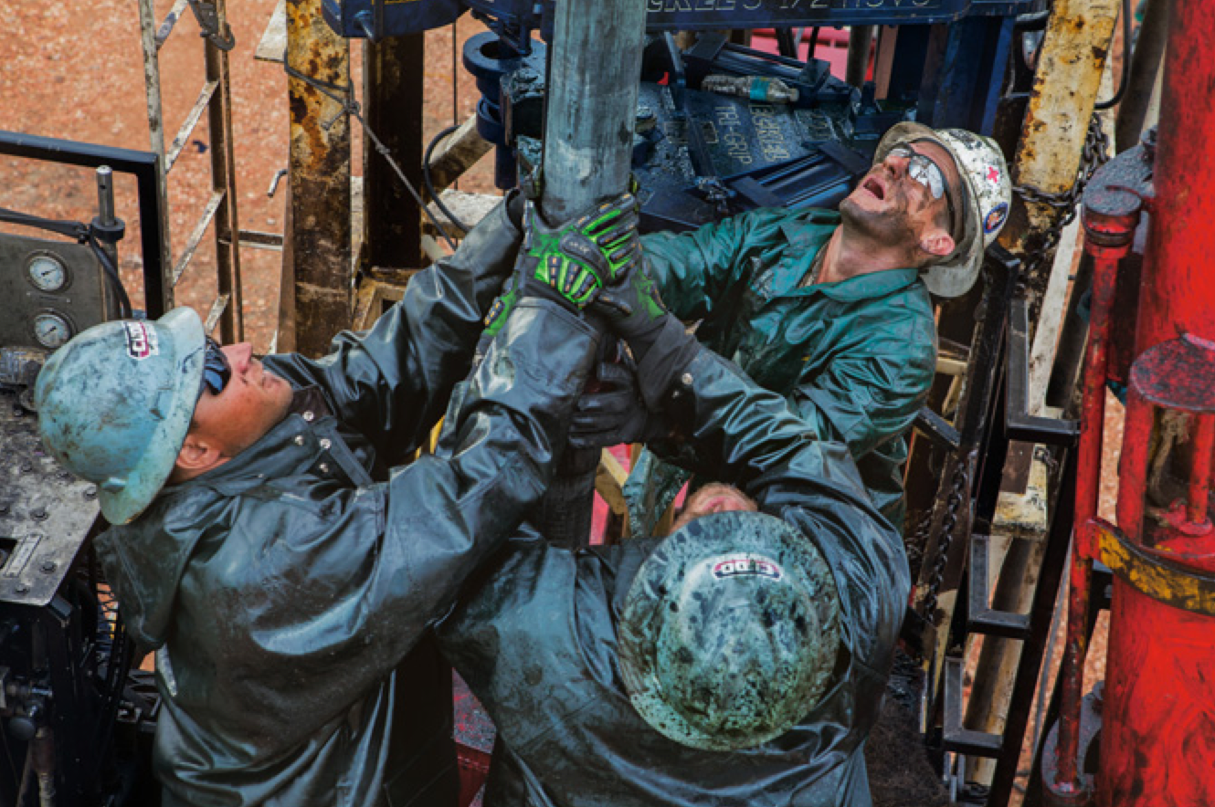 Roughnecks removing two miles of heavy steel drilling pipe one 32-foot section at a time. (Credit: Eugene Richards )