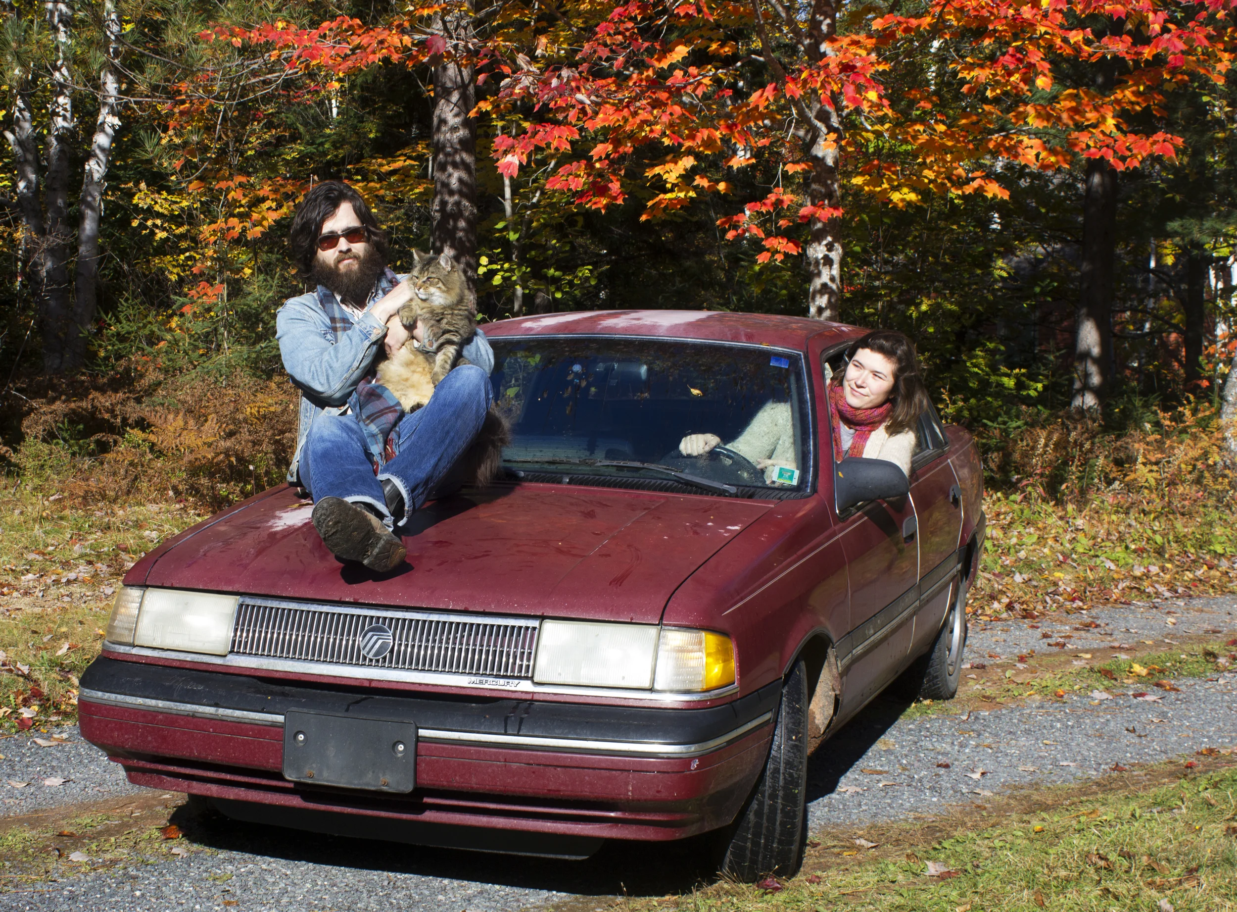 Arial Sharratt and Mathias Kom with new car and old cat