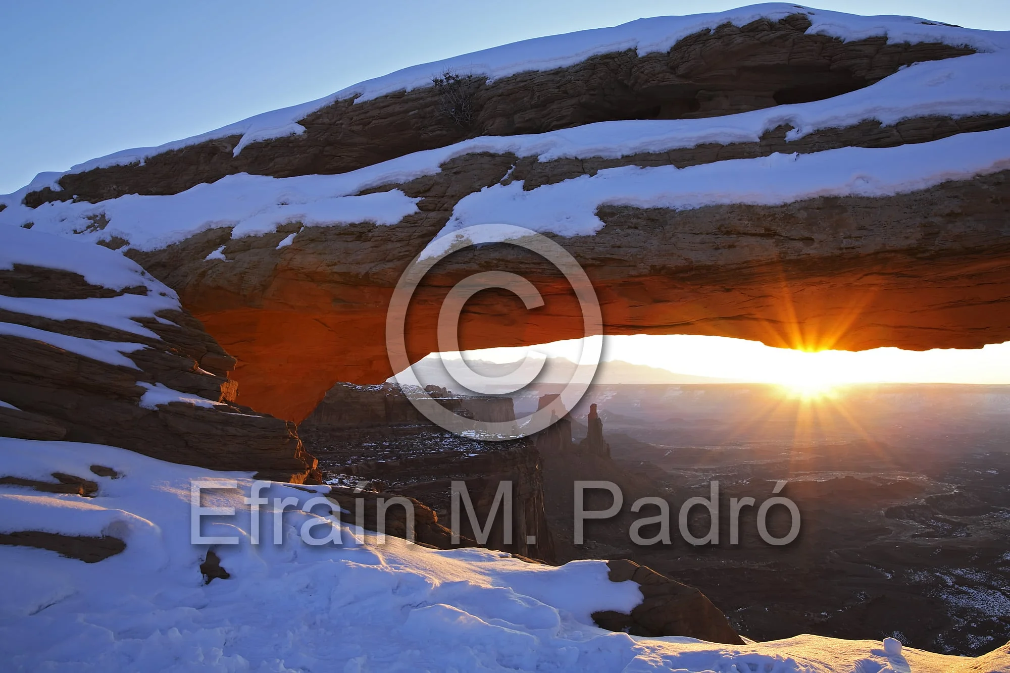 Mesa Arch covered in snow and sunburst, Island in the Sky District, Canyonlands National Park, Utah