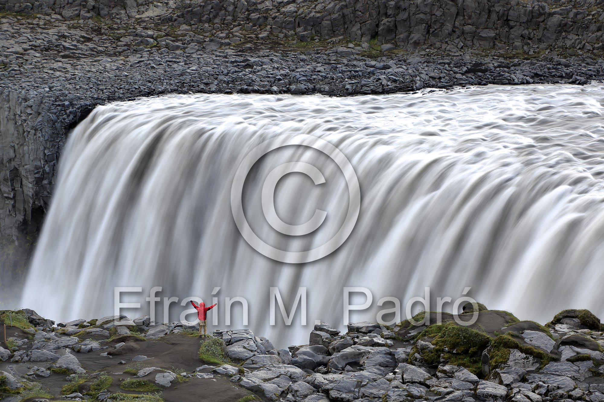 Hiker on rim of Dettifoss Waterfalls, near Reykjahlid, Iceland