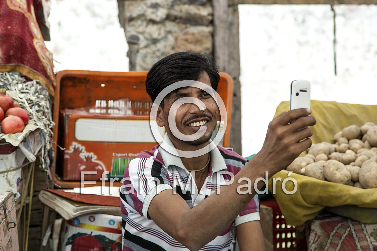 Produce vendor photographing tourists, Abaneri, Rajasthan, India