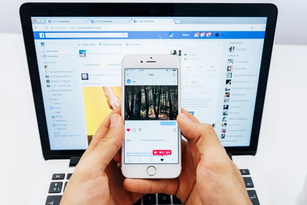 hands-holding-phone-with-instagram-and-laptop-with-facebook_23-2147651274.jpg