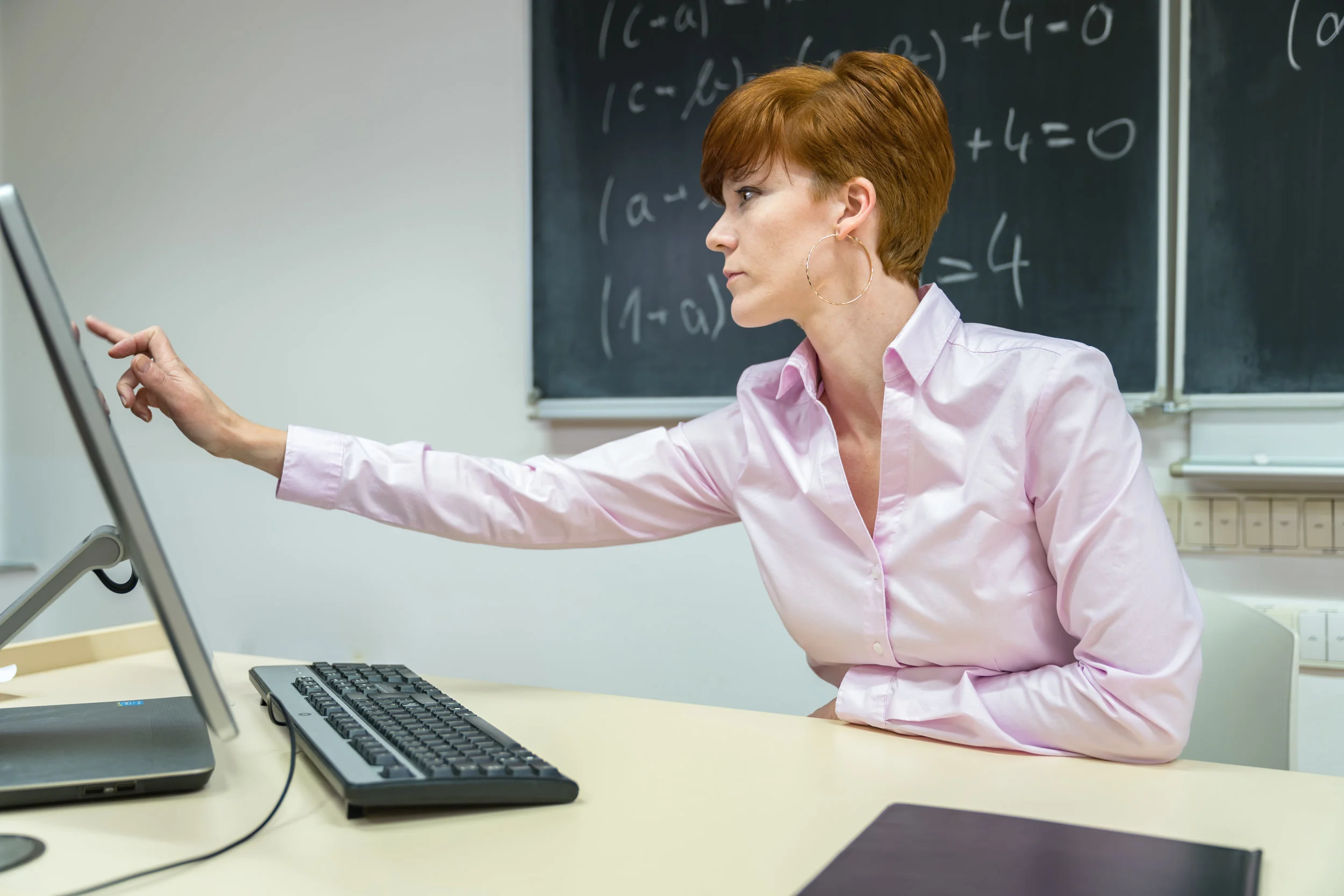 young woman prepares a teaching lesson in class on her computer