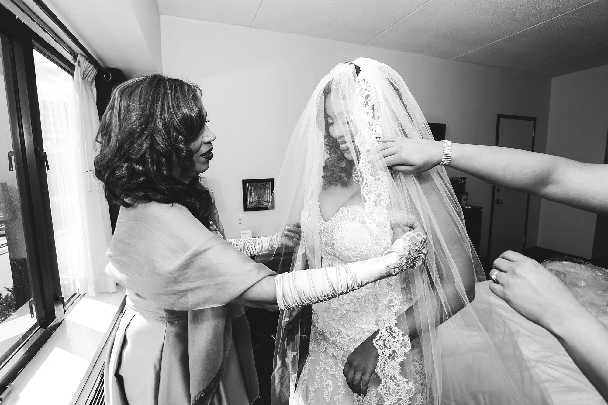 black and white image of bride getting ready in room