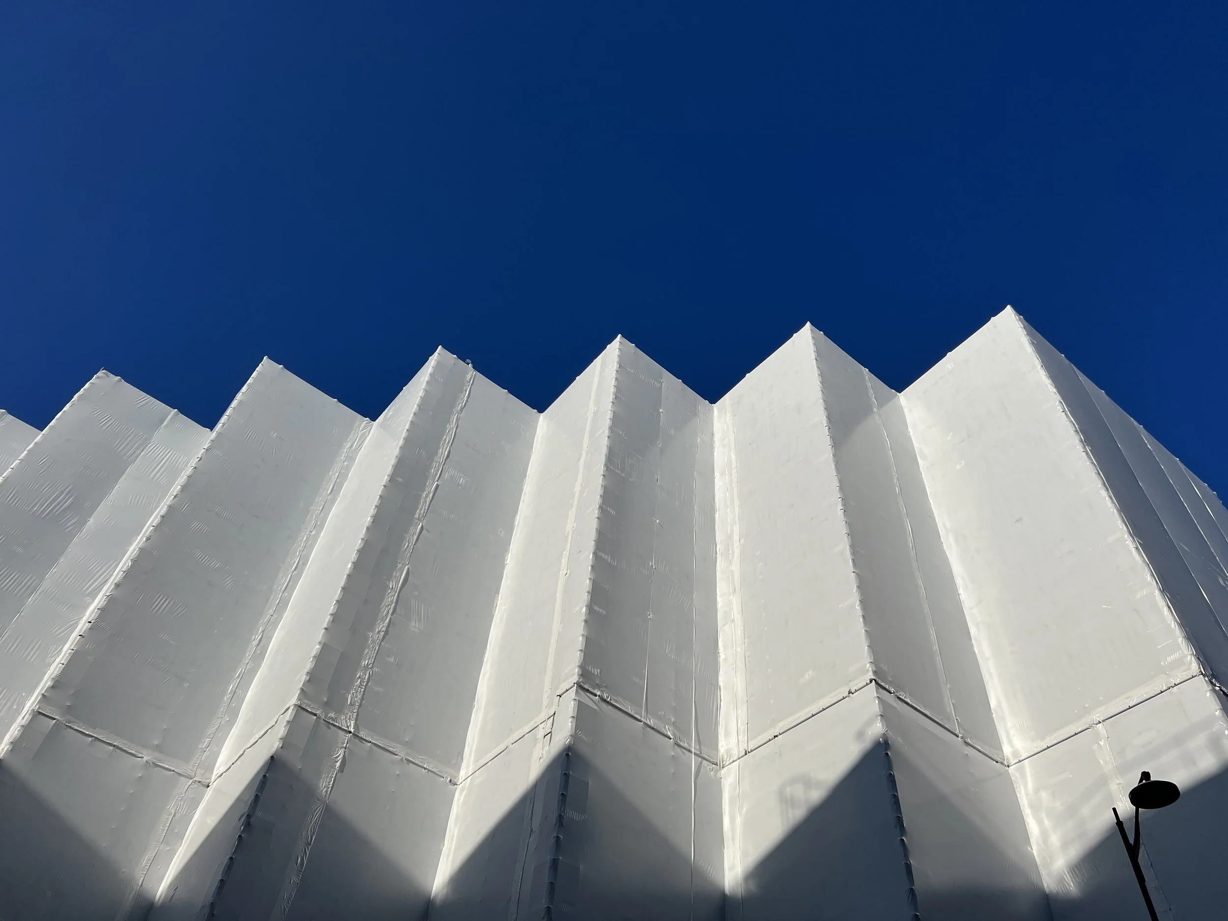 Façade d'un bâtiment blanc, ciel bleu clair.