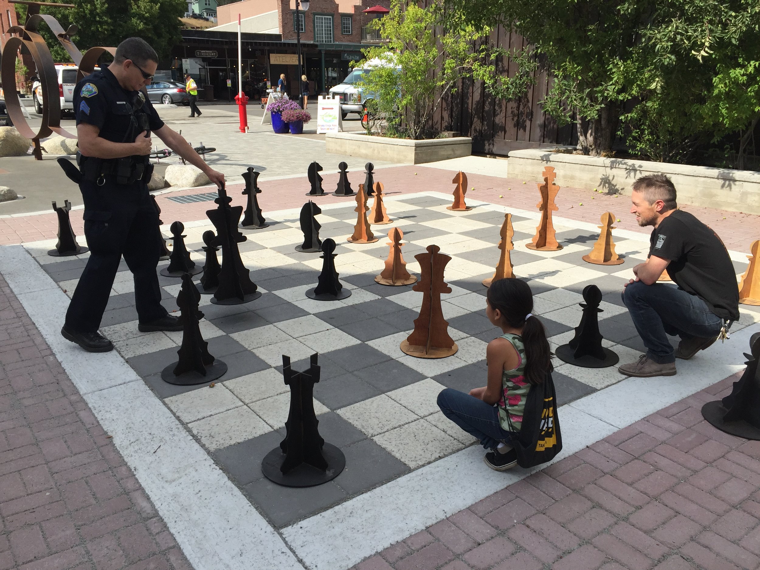 The very first chess game played between officer Jon MonPere and Roundhouse board member Morgan Goodwin, with help from a local 5th grader.